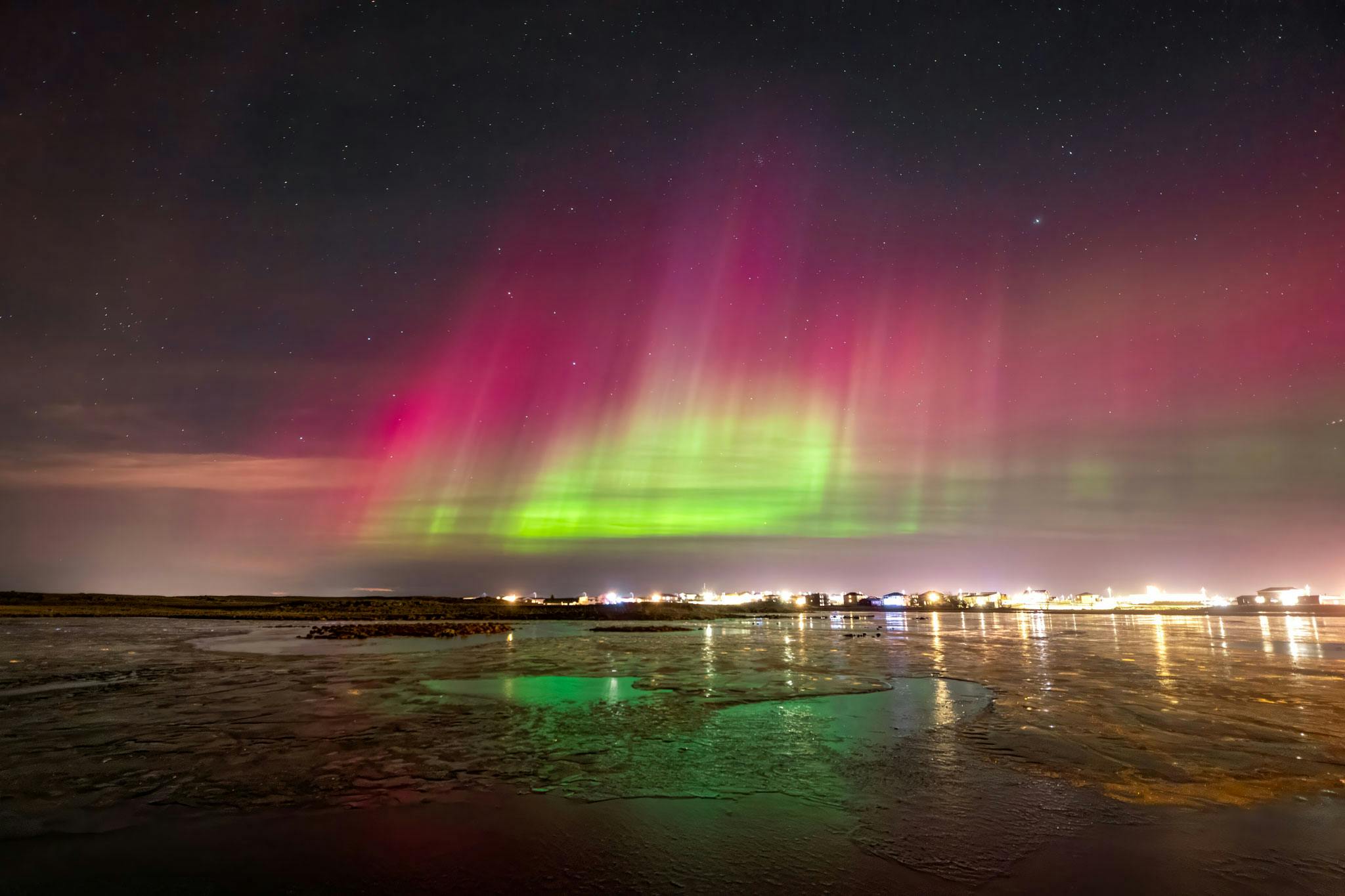 Red and green northern lights over reykjanes peninsula
