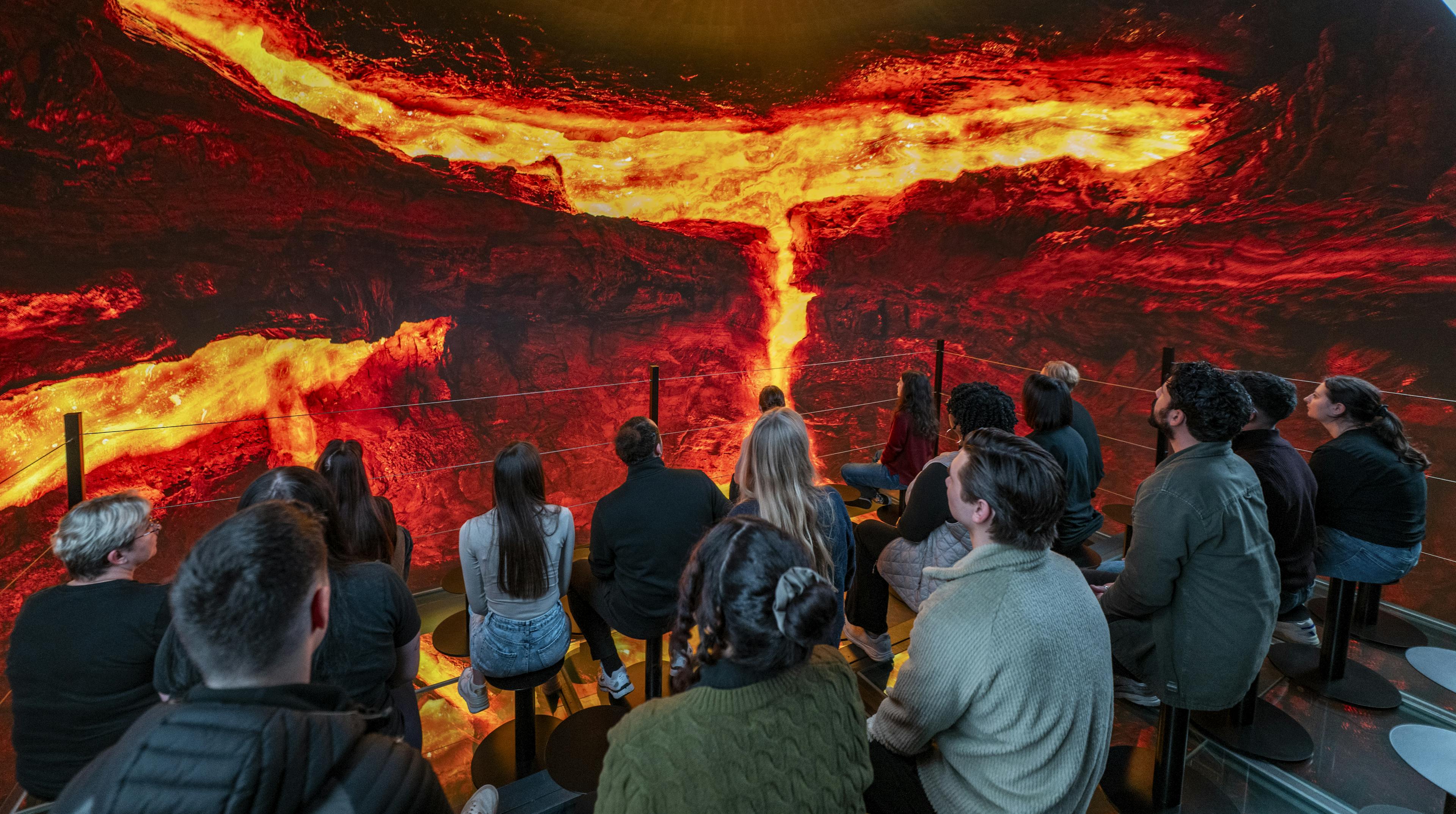 group of people surrounded lava in the into the volcano exhibit in iceland