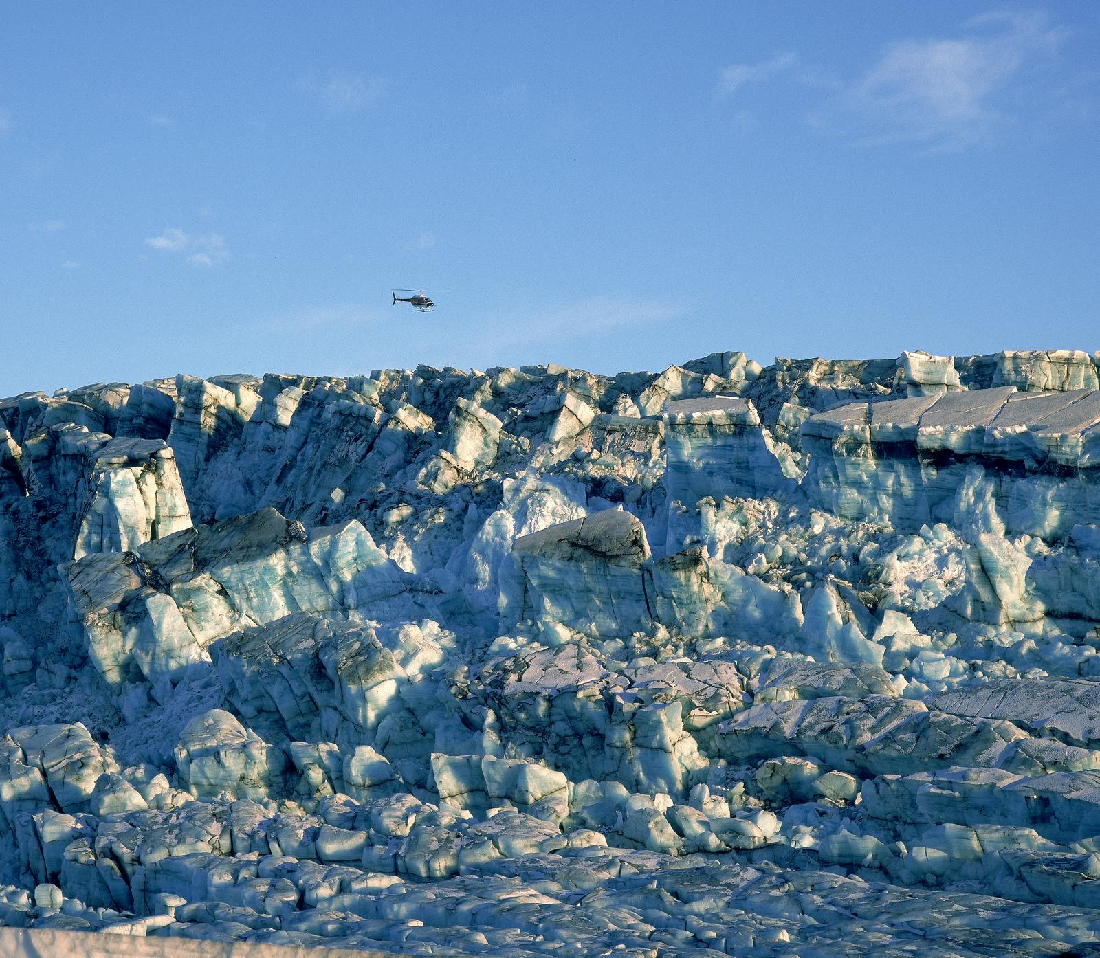 Helicopter flying over glacier