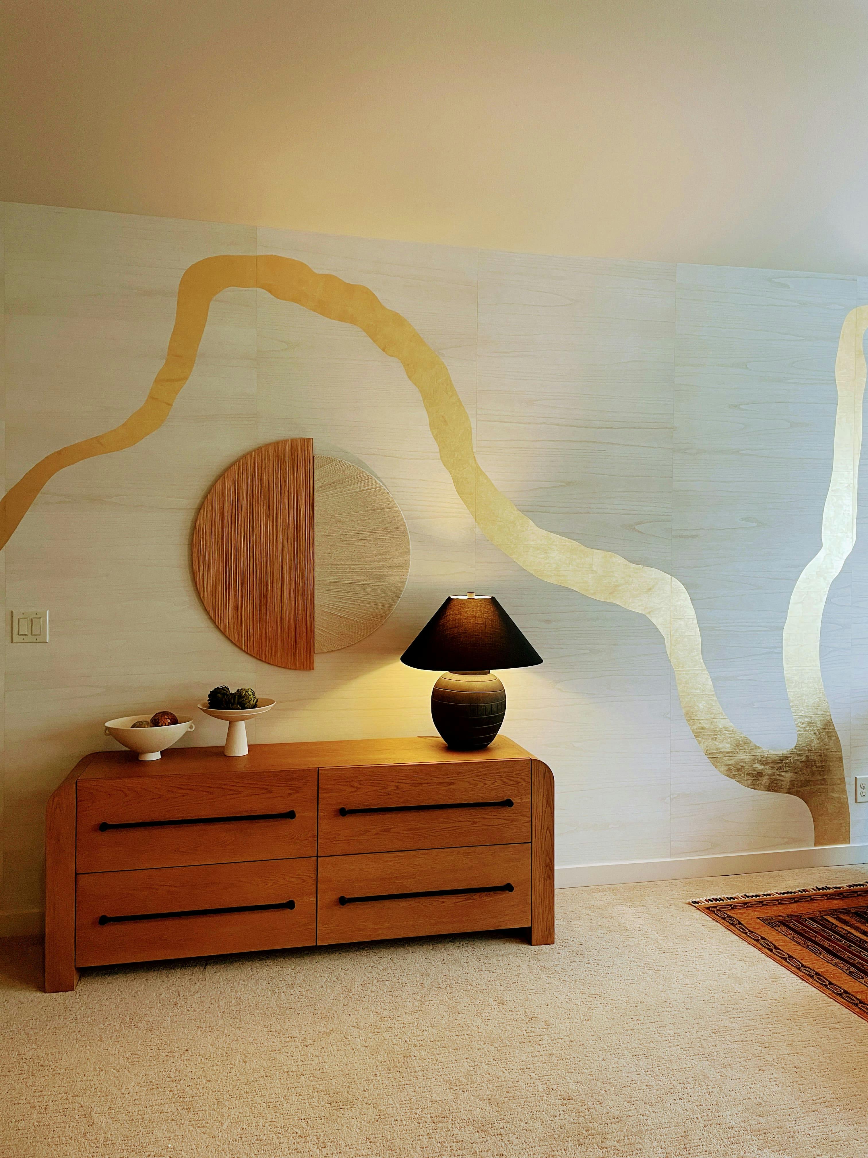 This bedroom designed by Persimmon Design showcases a wallcovering made from paulownia wood veneer, known for its high growth, carbon sequestration, and soil enhancing properties.