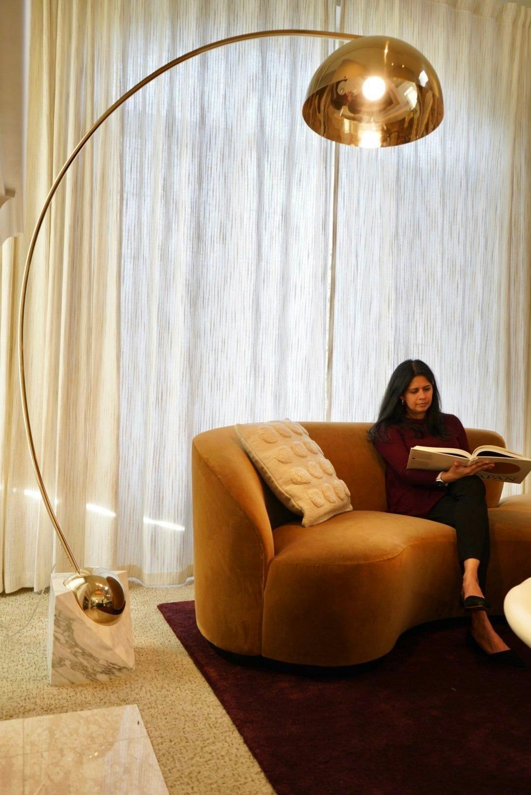 This luxurious living room by Persimmon Design features sumptuous honey-toned velvet paired with rich burgundy reds, creating a warm and inviting ambiance
