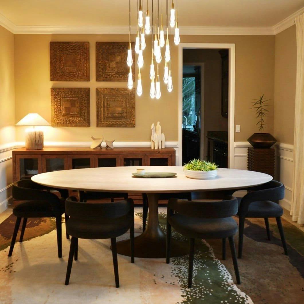 This dining room designed by Persimmon Design is bathed in layers of lighting that accentuates natural materials like travertine and the traditional craftsmanship of hammered metal. A custom rug anchors the whole ensemble.