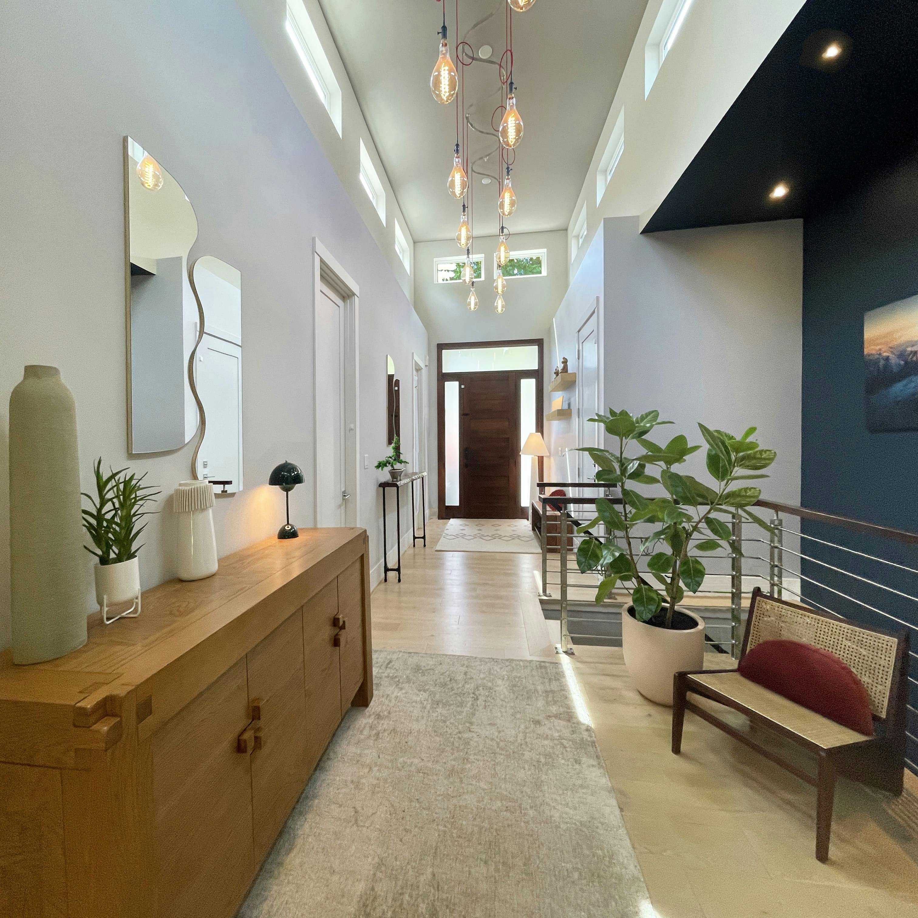 Entry hallway in Medina, WA designed by Persimmon Design features natural materials and energy efficient statement lighting with smart controls