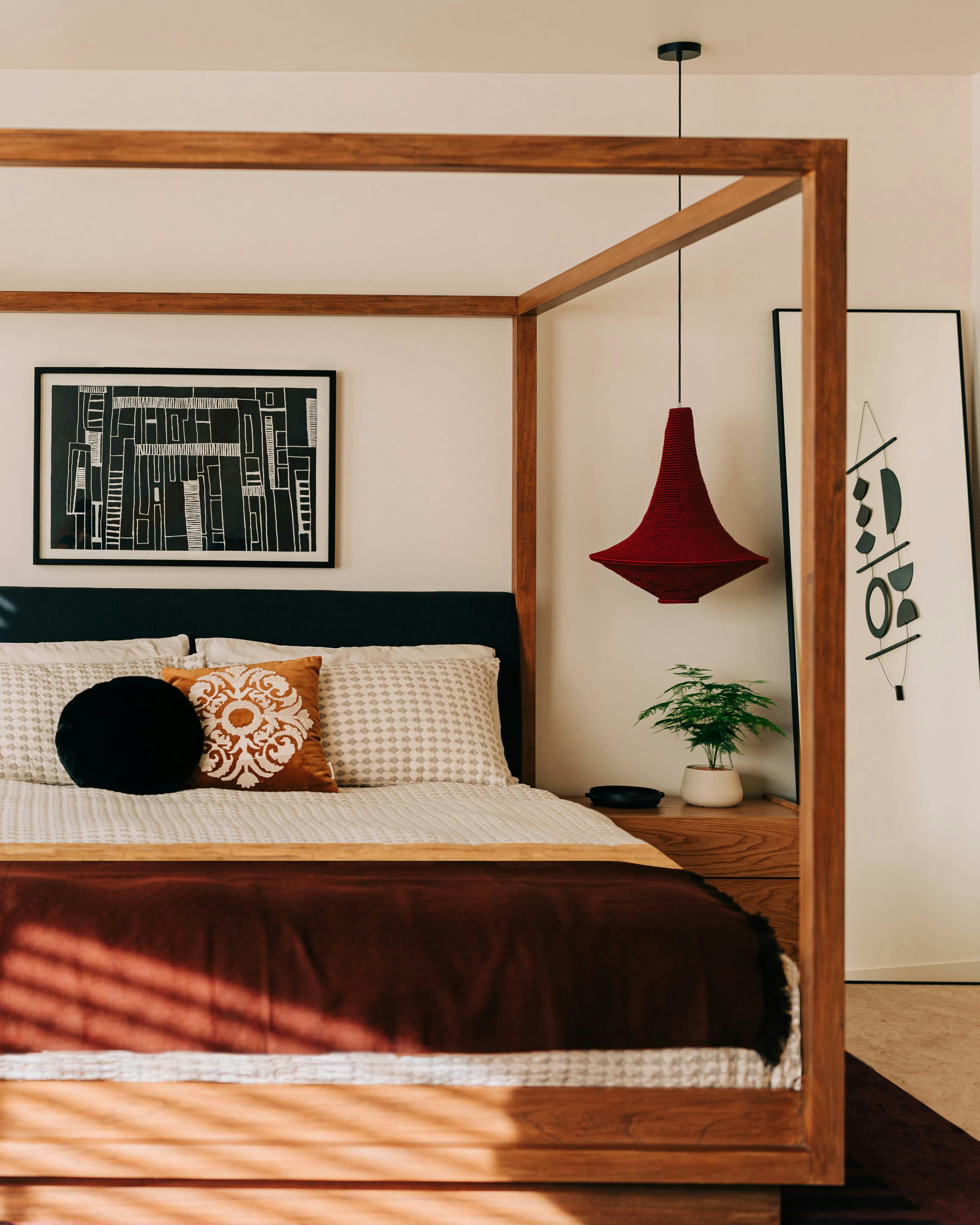 A dramatic canopy bed and artisan made pendant lighting set the tone for this Master Bedroom by Persimmon Design