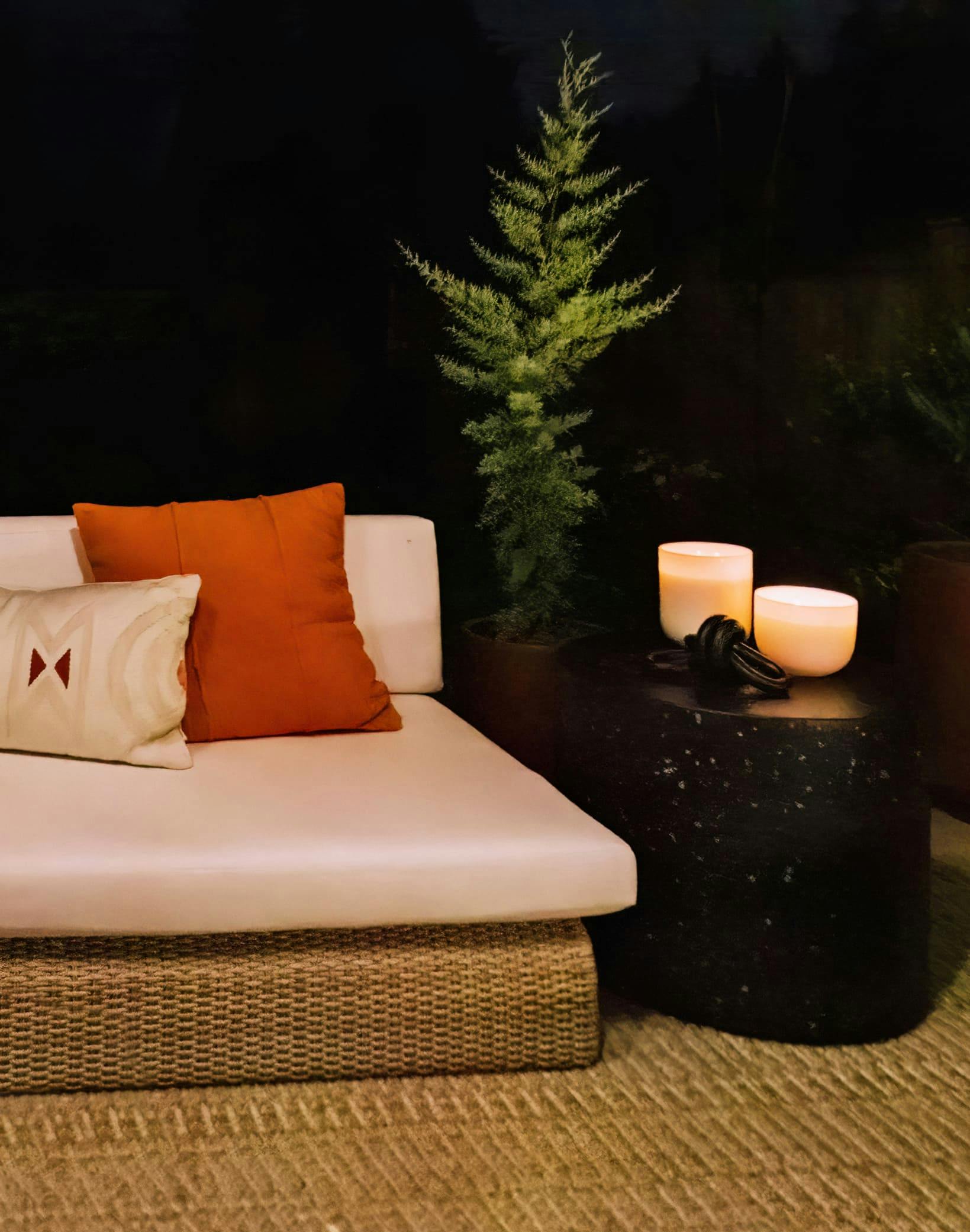 Warm candlelight, greenery, rich colors, and textures beckon you to relax and enjoy an evening breeze in this outdoor deck by Persimmon Design