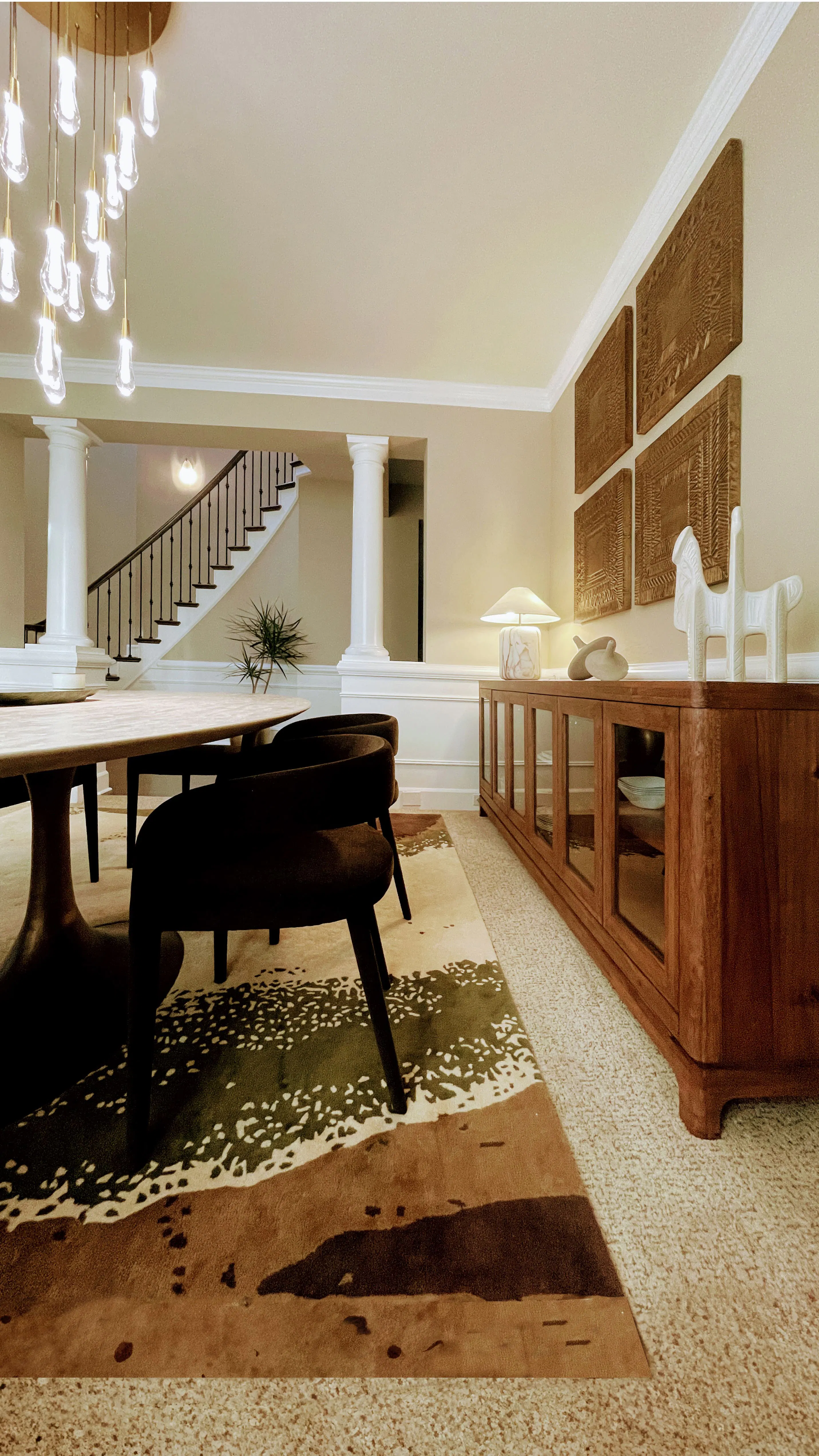 In this dining space designed by Persimmon Design, the subtly lowered ceiling creates an intimate, grounded atmosphere in deliberate contrast to the soaring double-height stairwell beyond, using proportion rather than walls to define comfort and containment.
