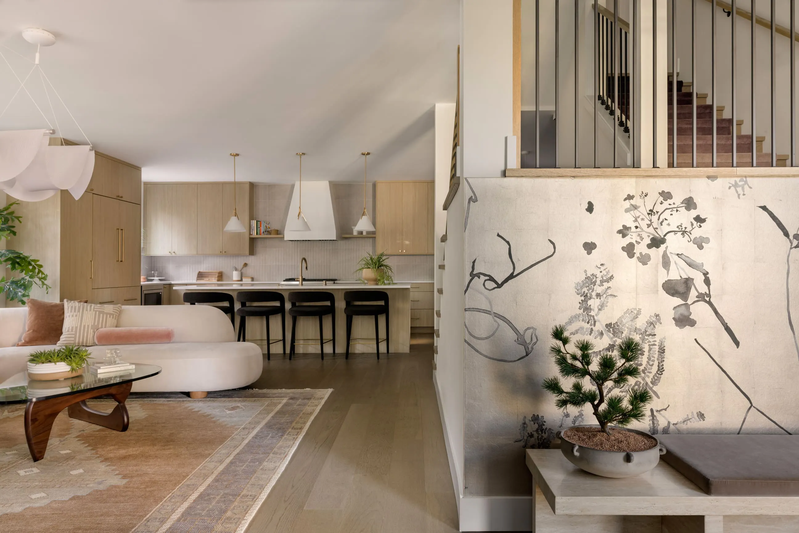 Nearly every surface in this space by Persimmon Design is doing the quiet work that Seattle interiors depend on — the textured wallcovering, the bouclé sofa, the matte vintage rug, the brushed brass hardware — each one chosen to diffuse light softly, layering warmth and depth into the room.