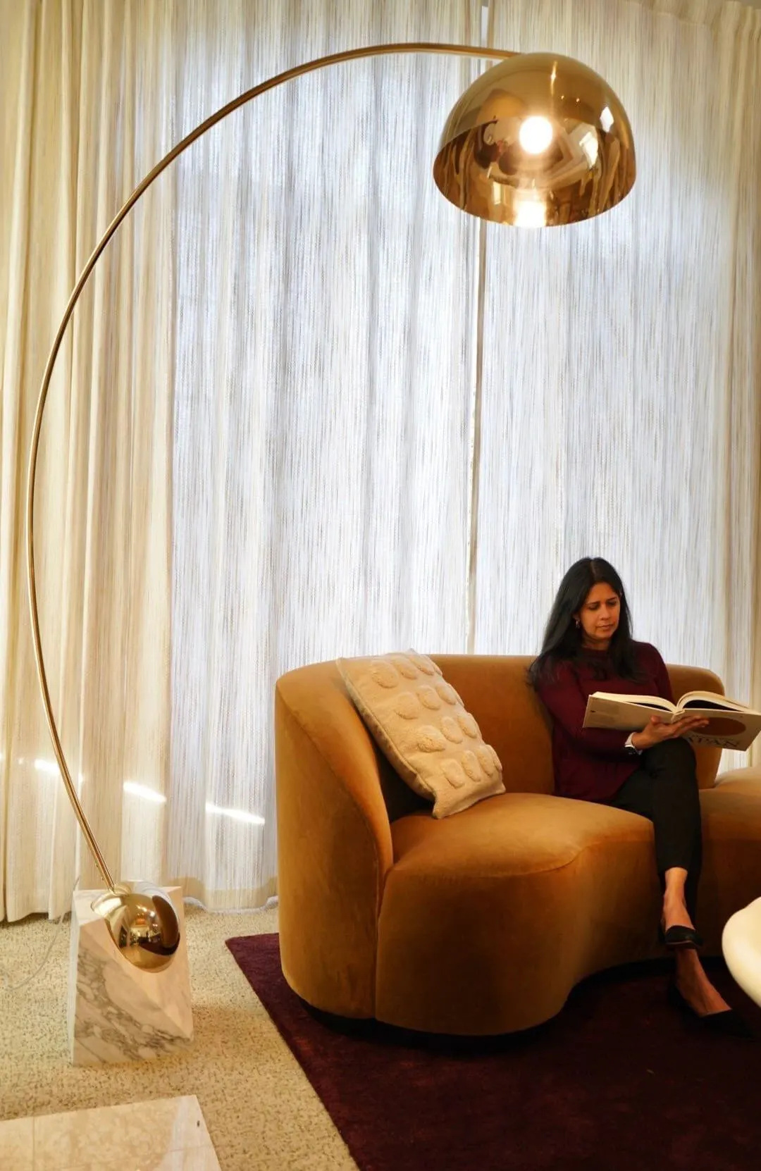 The sweeping arc of the lamp, the low sculptural sofa, and the full-height drapery work together to turn height, softness, and negative space into a composition that feels both expansive and intimate at once - Living Room designed by Persimmon Design.