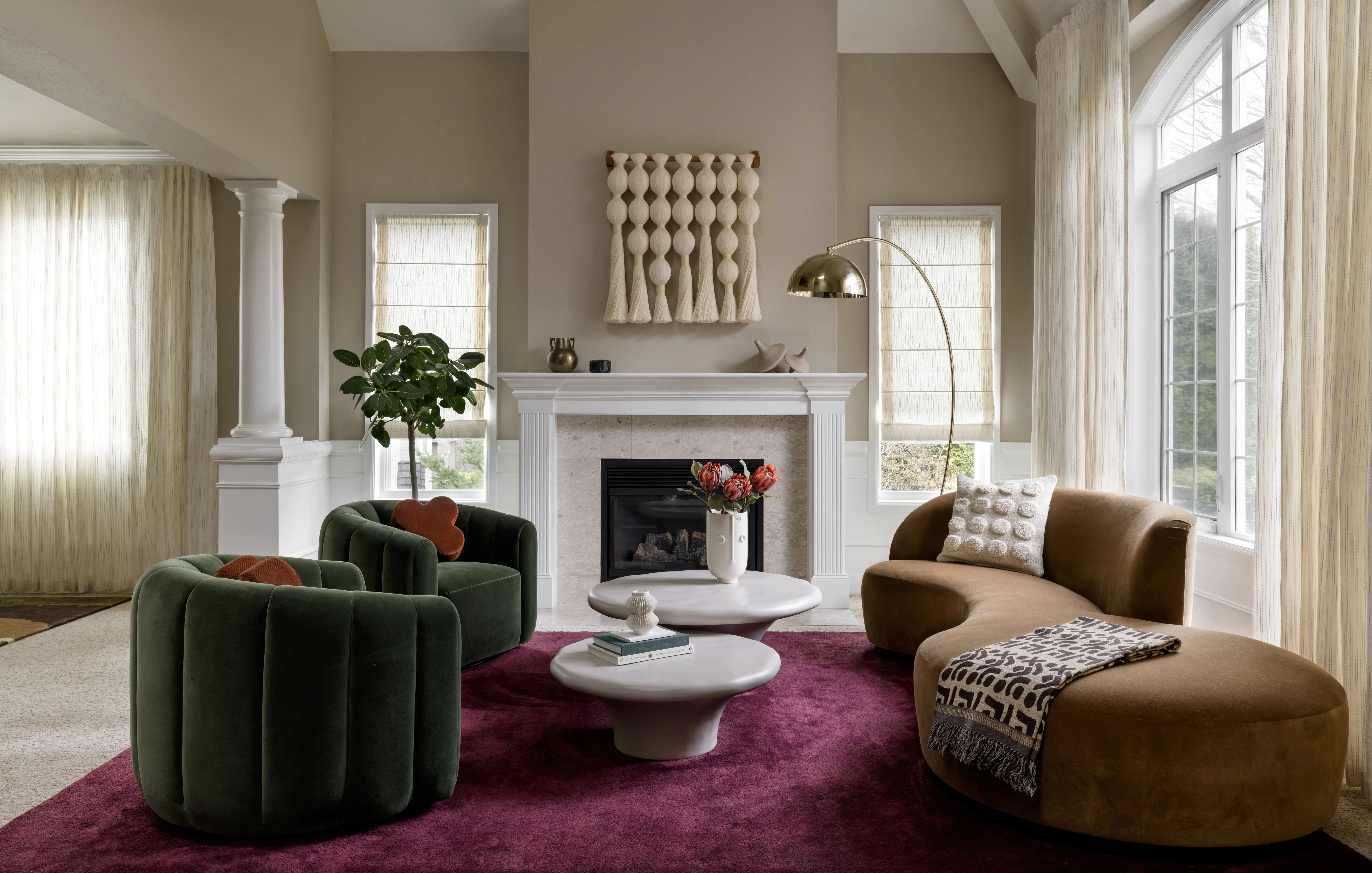 In this living room by Seattle Interior Designer - Persimmon Design, the generous curve of the sofa, the grounded presence of the chairs, and the scaled relationship between the seating group and the soaring architecture allow the space to feel anchored, graceful, and fully resolved.