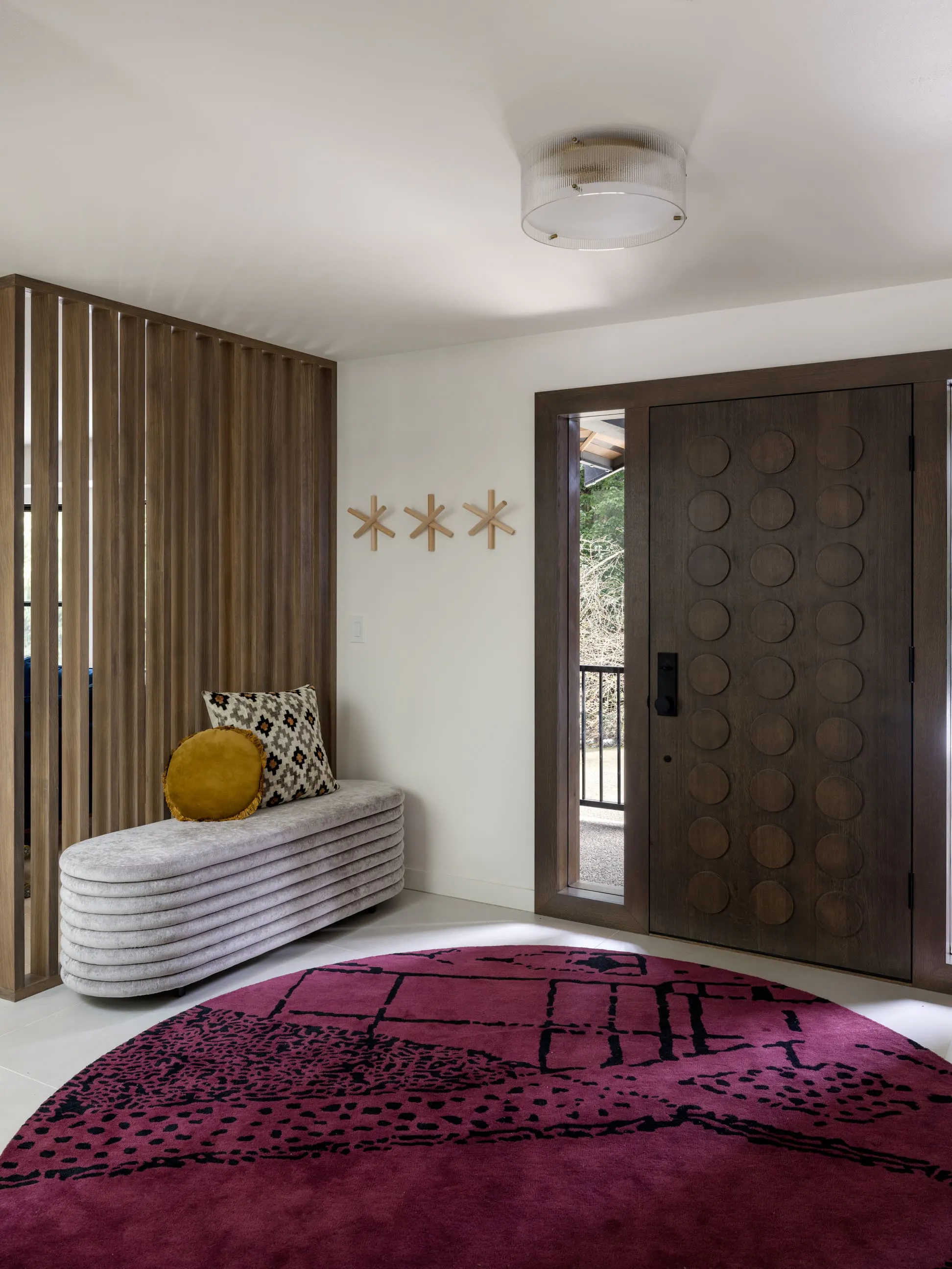 In this entry foyer by Persimmon Design, the saturated Plum tone of the wool rug grounds the space, while smaller moments of color support rather than compete—allowing the composition to feel both expressive and composed.