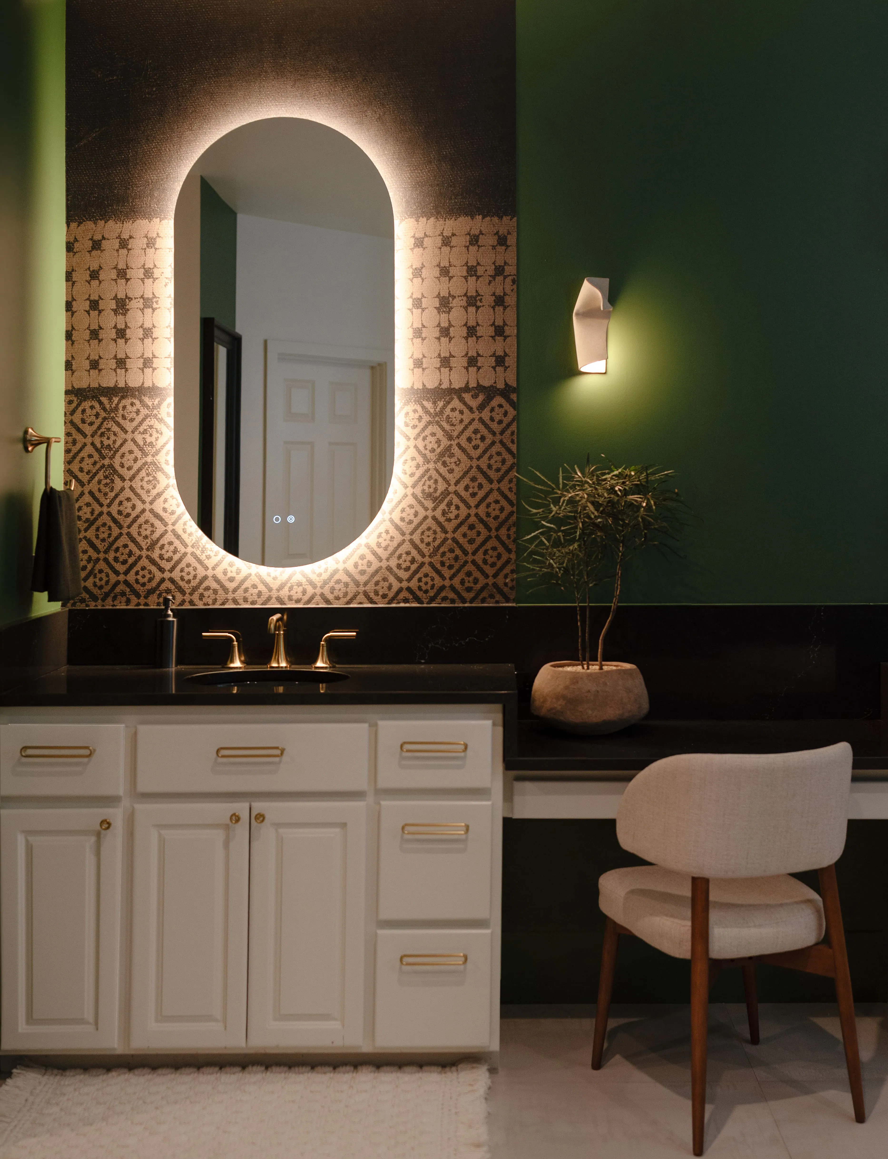 In this Primary bathroom designed by Persimmon Design, the polished chocolate brown counters and subtle glimmer of the brass plumbing fixtures introduce moments of clarity and reflection, while the matte walls and textured surfaces keep the room feeling grounded and intimate. Together, the contrast creates a layered balance where light is reflected with intention rather than excess. Photography by Alexis Grosclaude