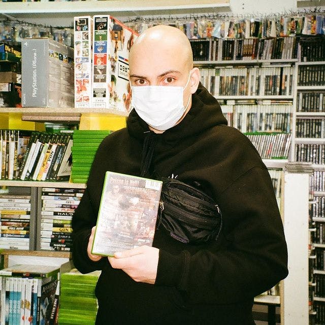 Georgi Nikolov with a mask on sitting in a retro video game shop