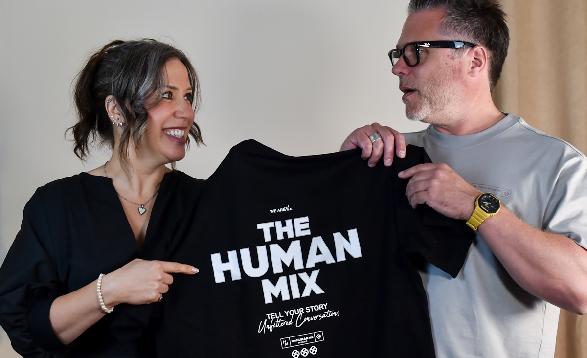 Nick and Lydia holding a Human Mix t-shirt