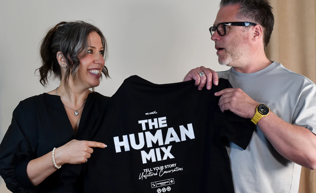 Nick and Lydia holding a Human Mix t-shirt