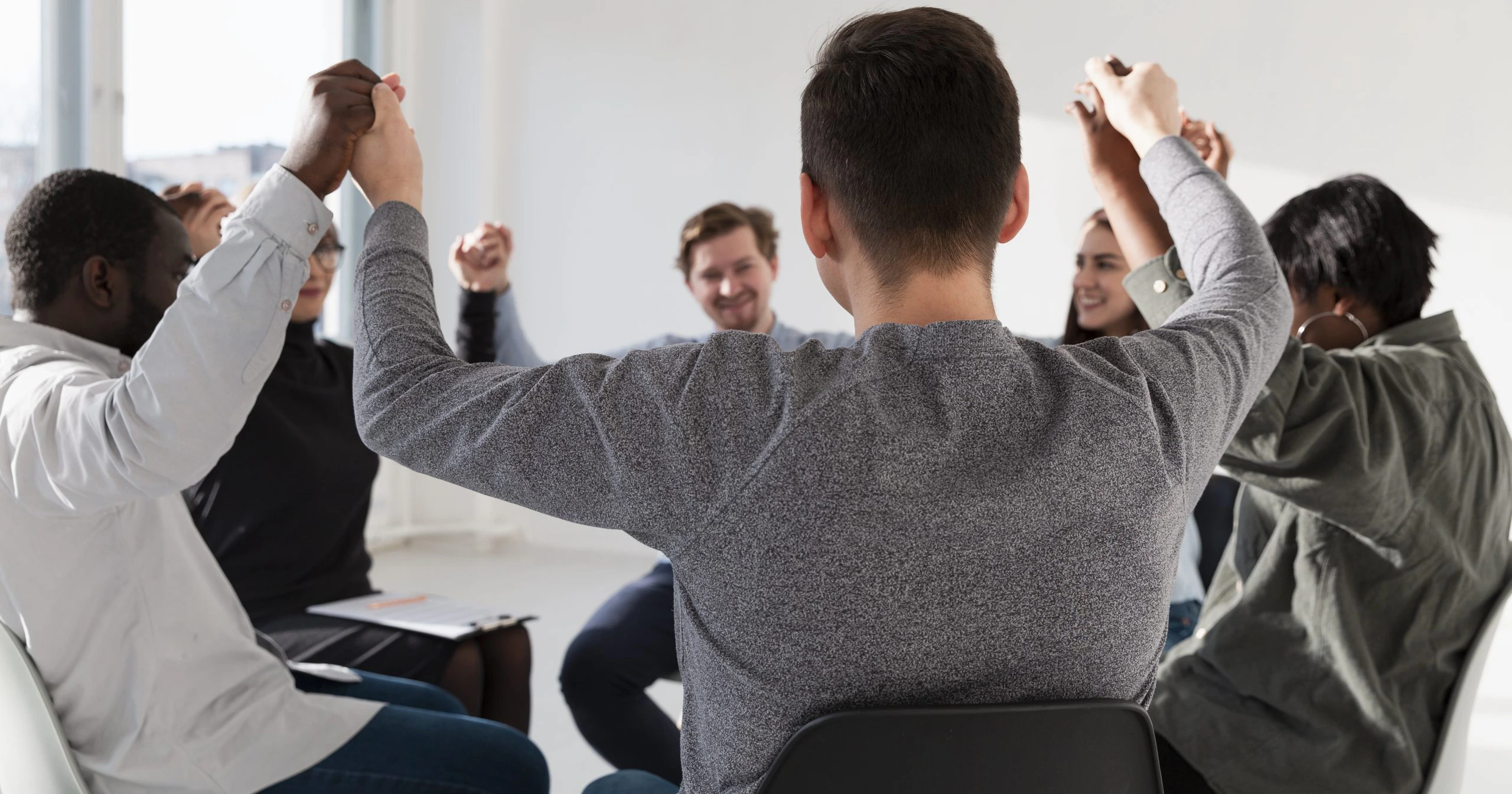 A group of learners holding hands in a circle