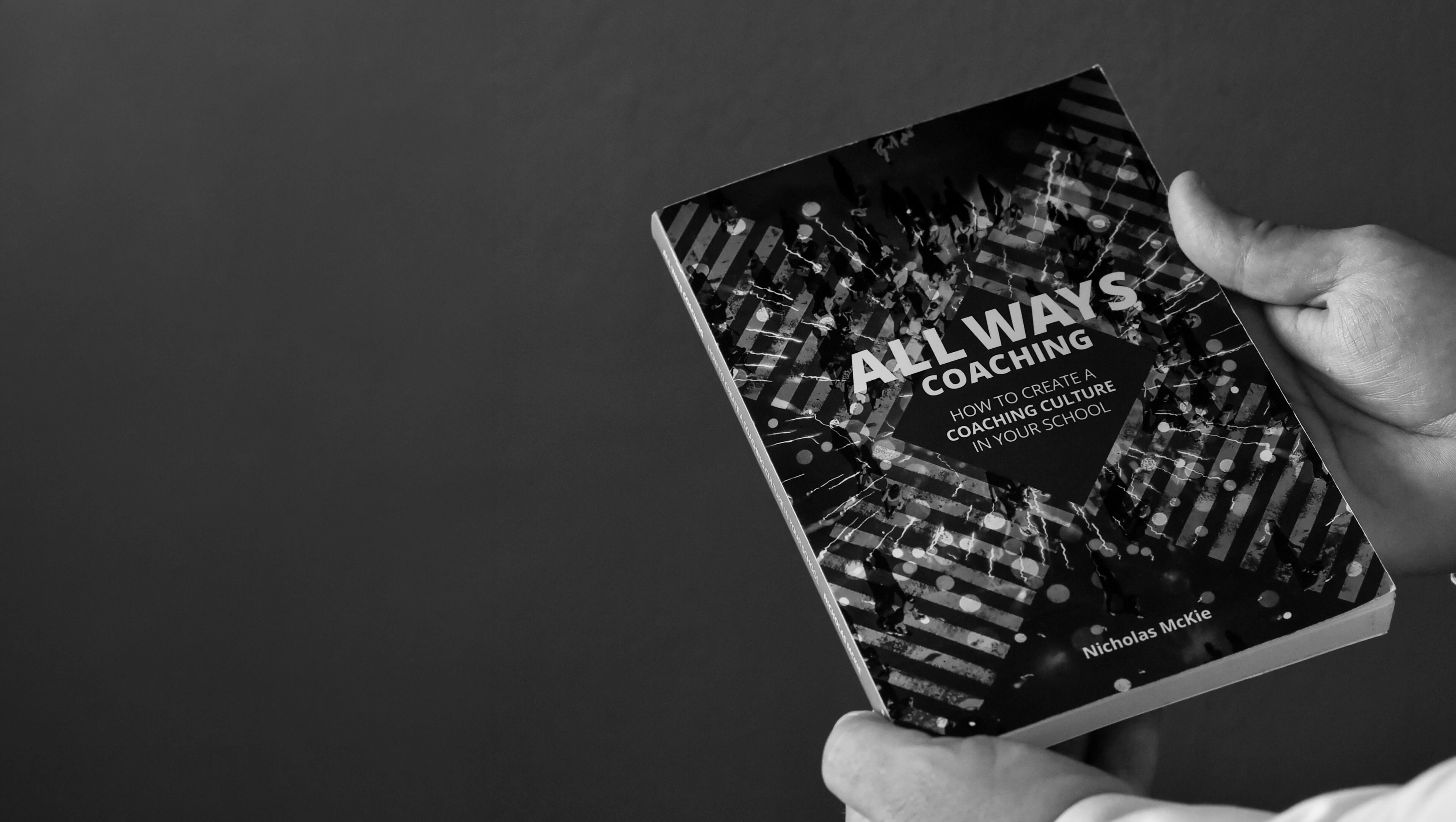 Hands holding the All Ways Coaching book
