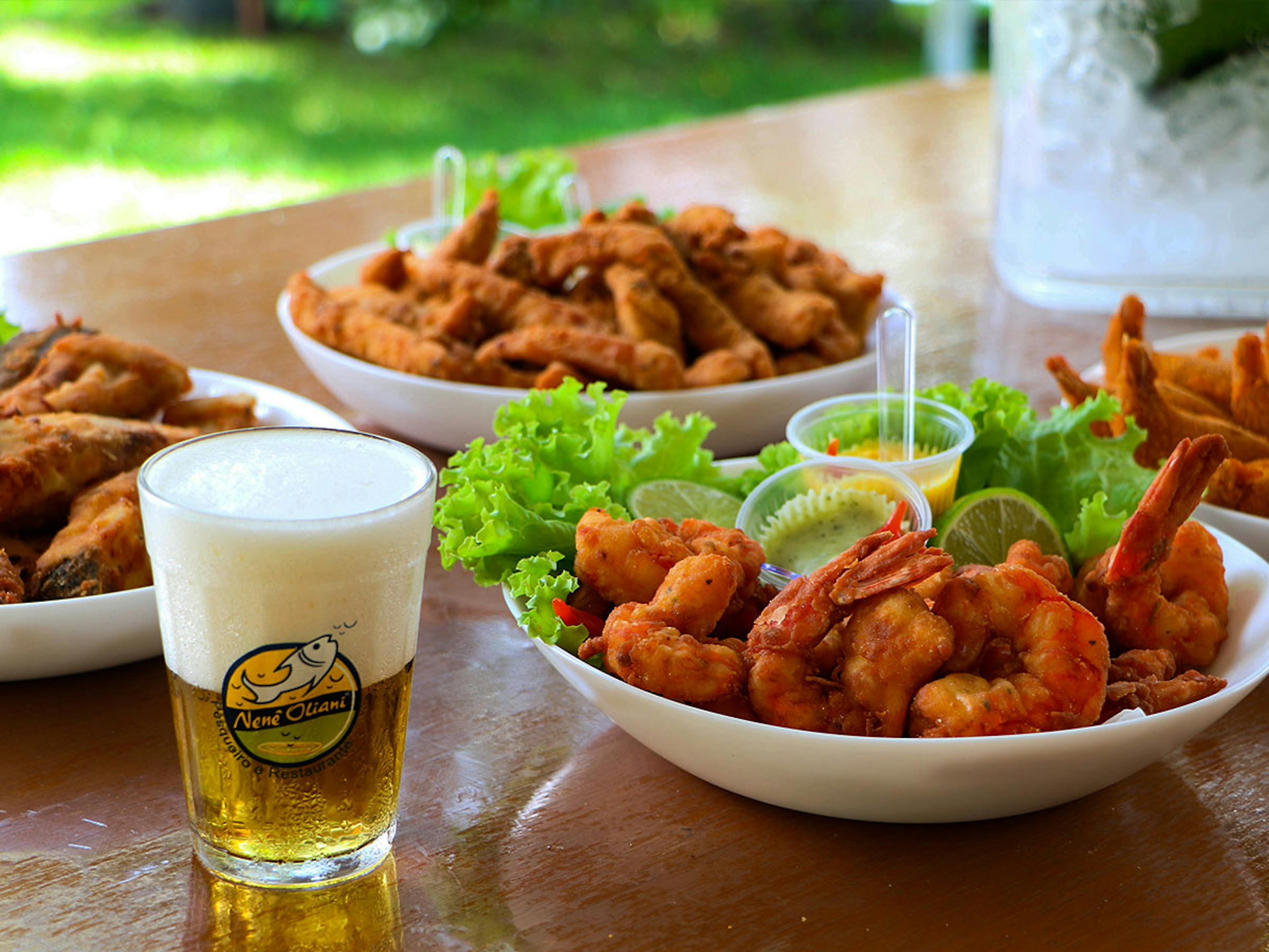 Pratos típicos do Pesqueiro e Restaurante Nenê Oliani: camarão, peixe empanado, cerveja e outros aperitivos