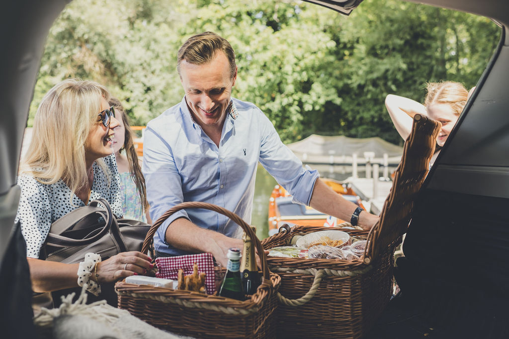 Classic boats for sale, couple unloading picnic hamper from boot of car adjacent to Freebody moorings