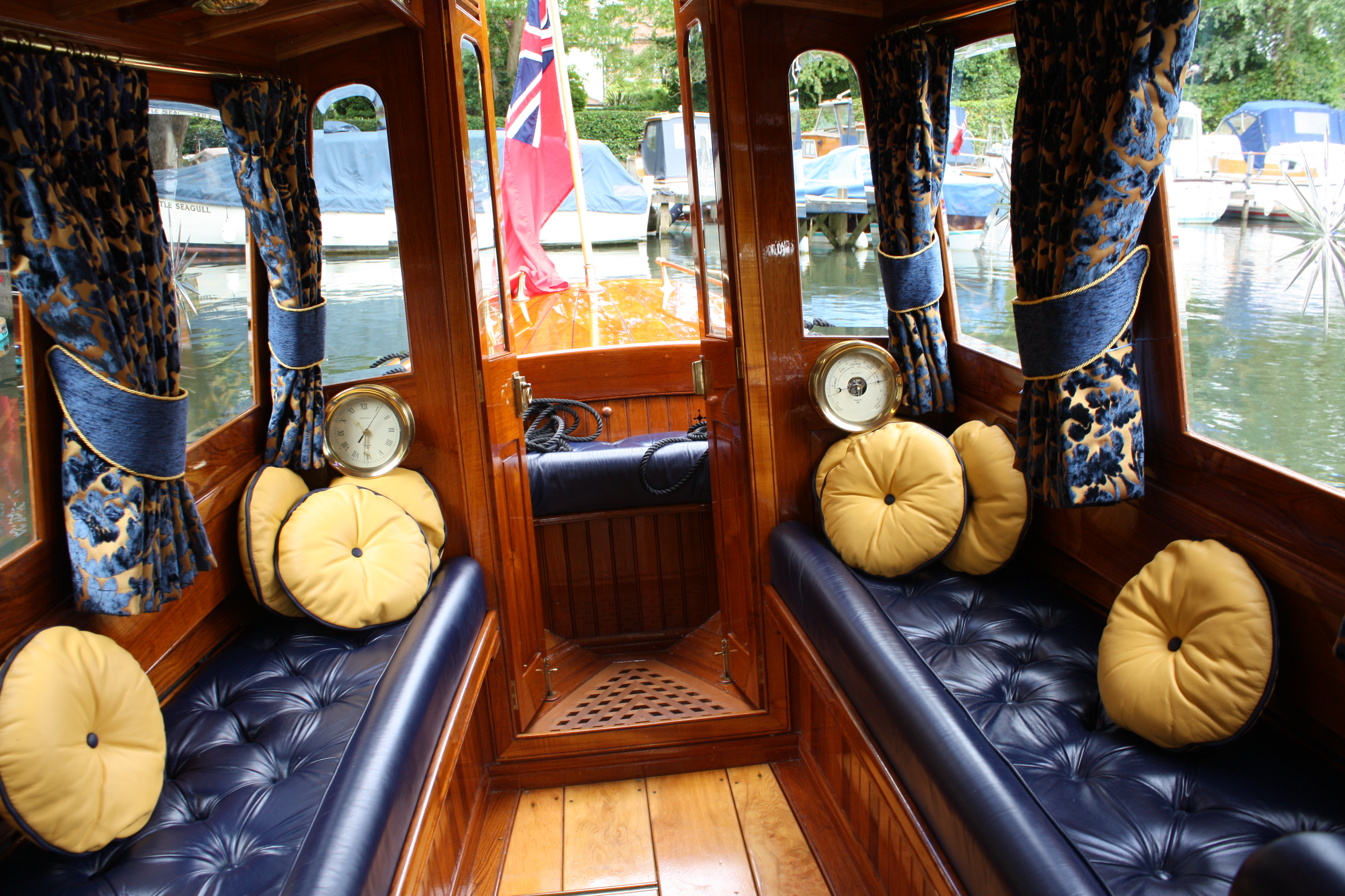Steam launch for sale, interior showing blue leather upholstery and bevelled glass windows