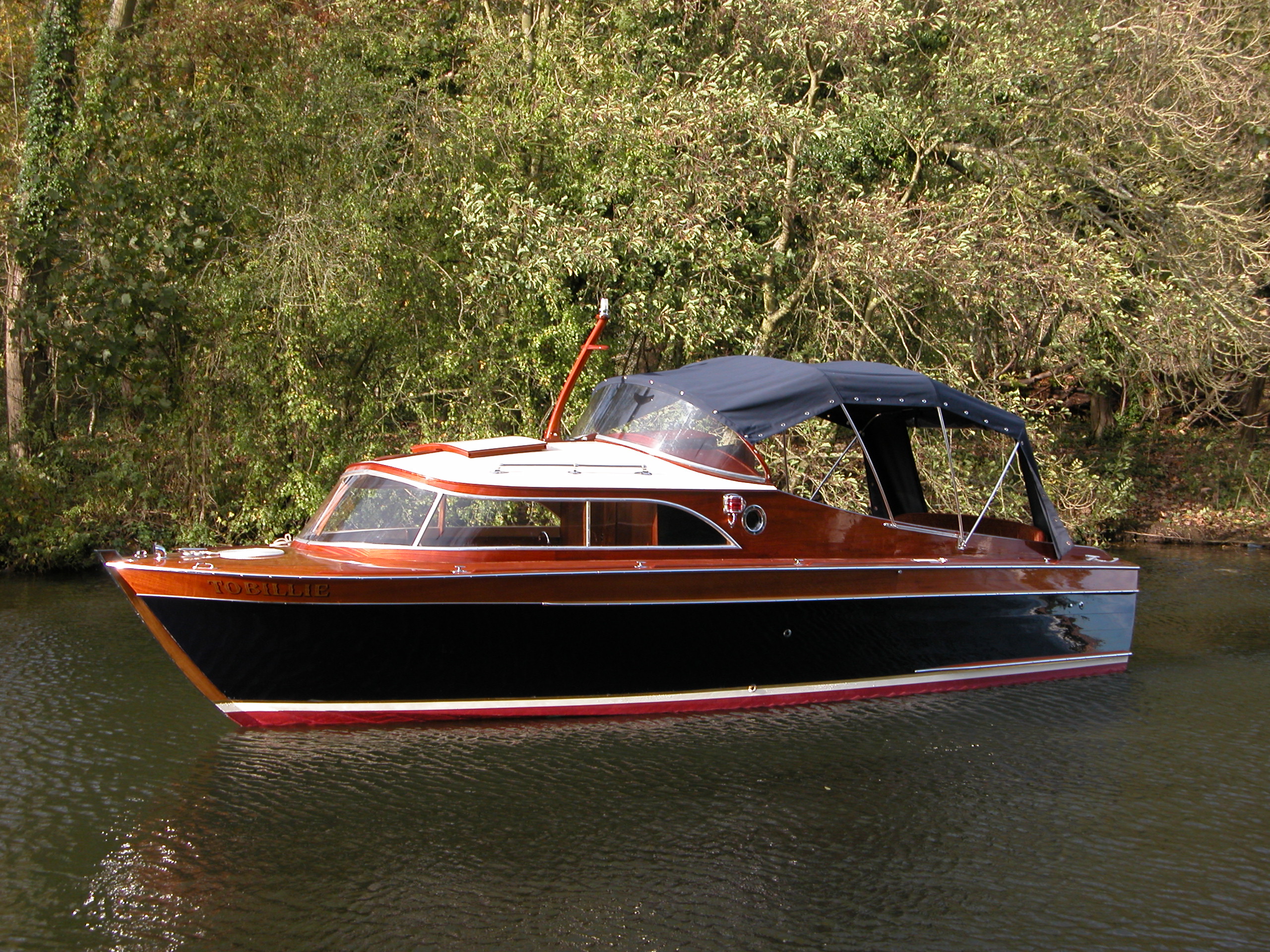 Cabin cruiser for sale, port side profile of boat on river Thames
