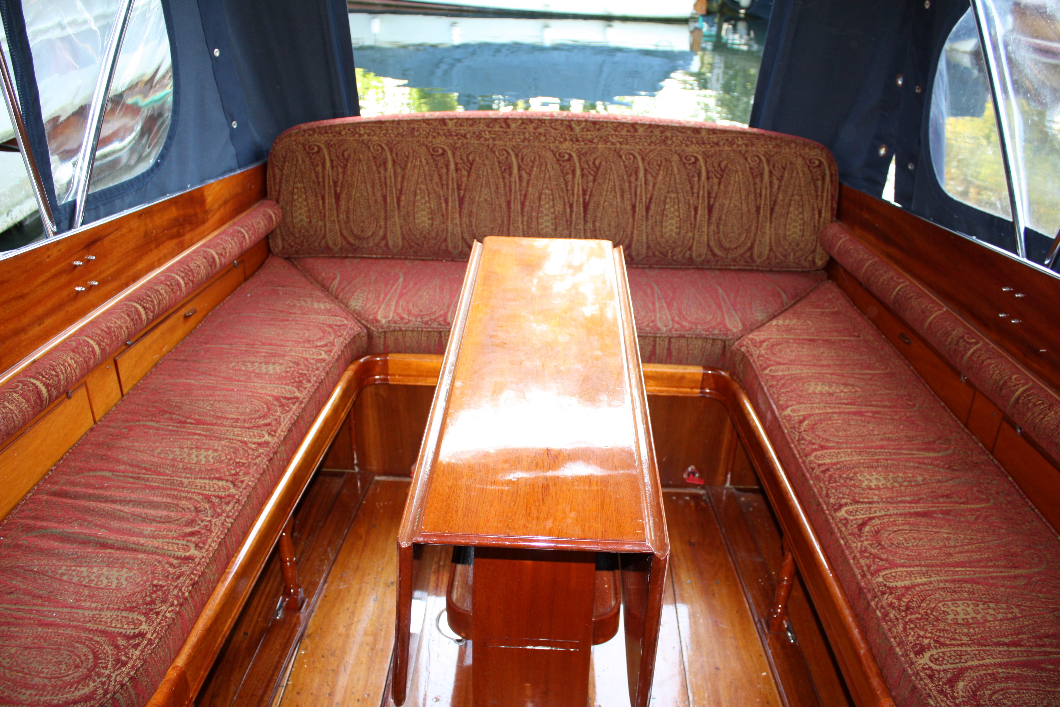 Cabin cruiser for sale, aft cockpit with dining table and upholstered seating