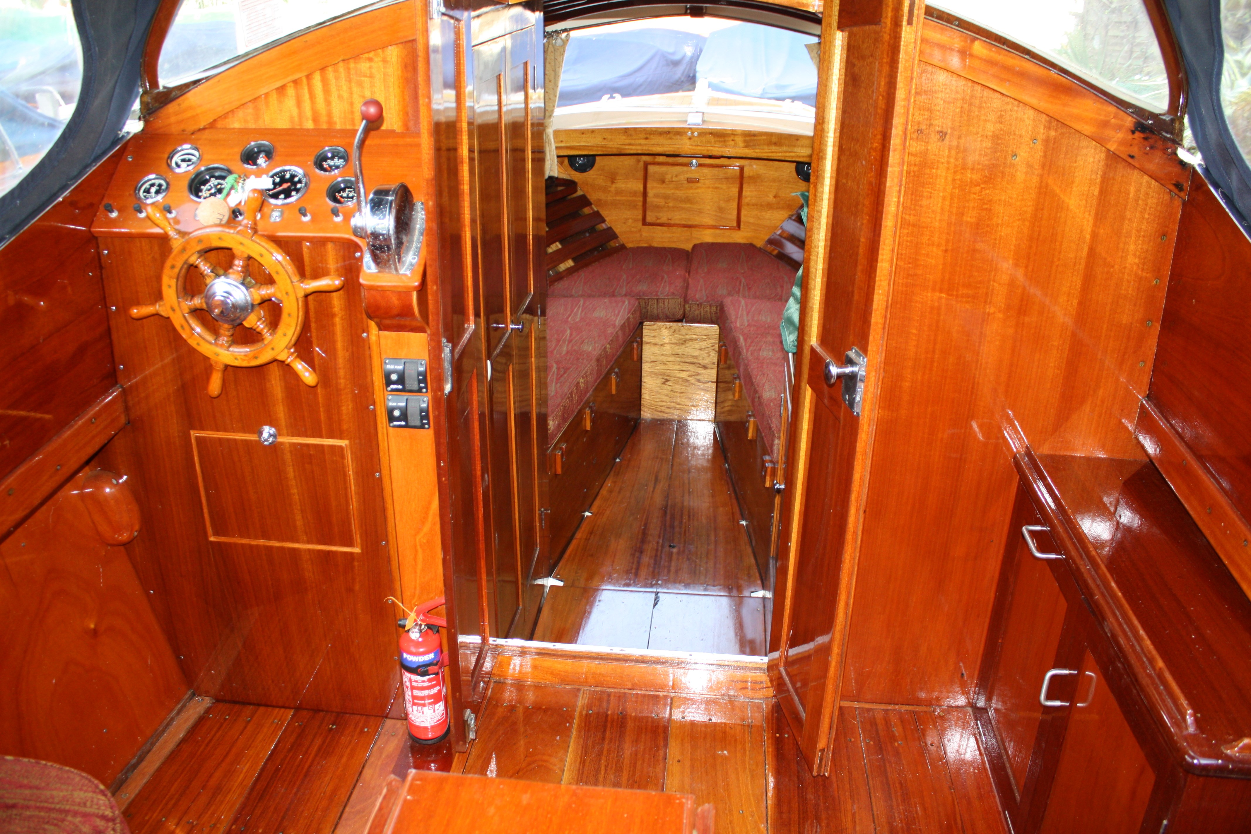 Cabin cruiser for sale, cockpit showing helm position, looking into forward cabin