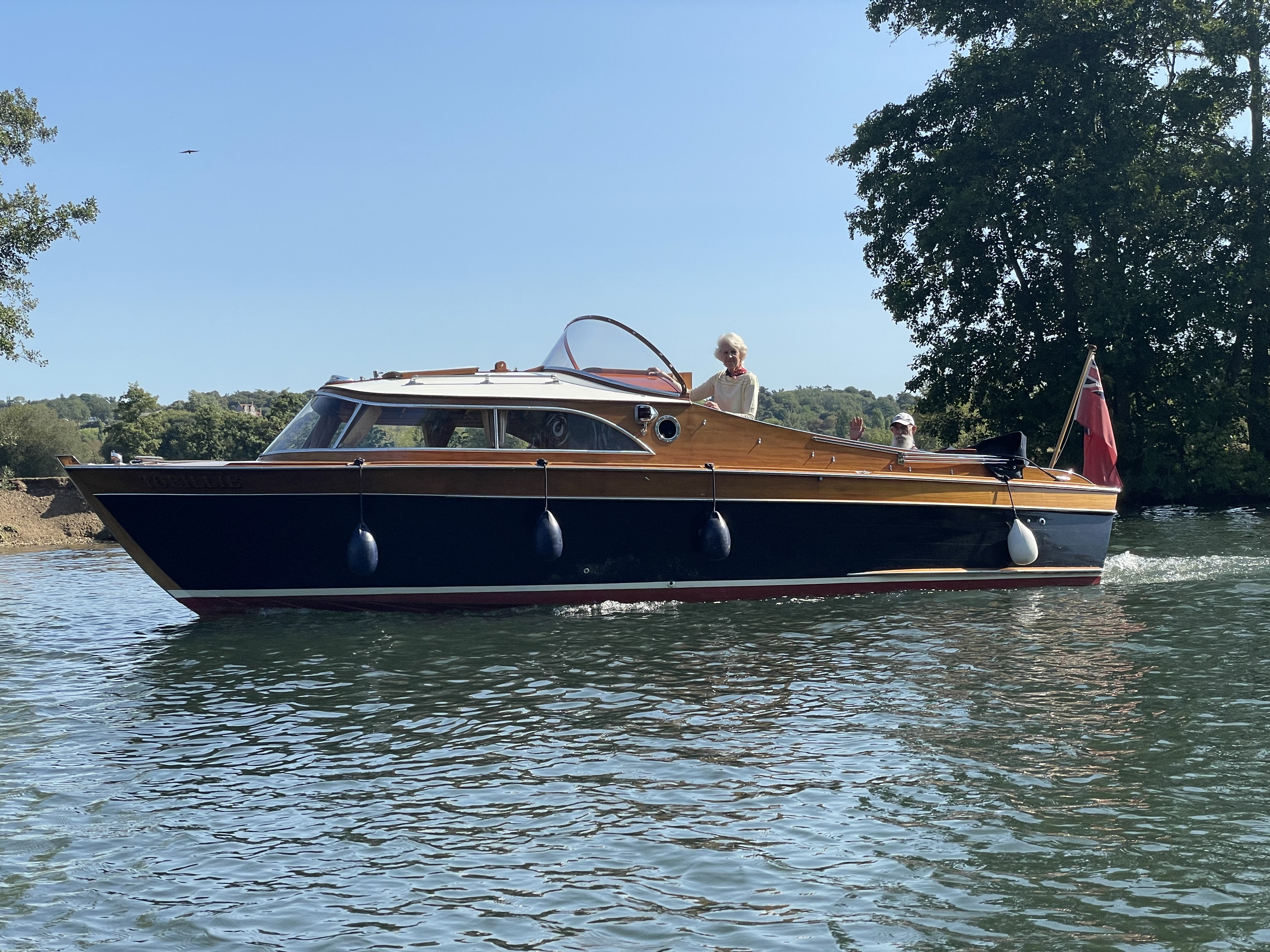 Cabin cruiser for sale, on river Thames with people on board