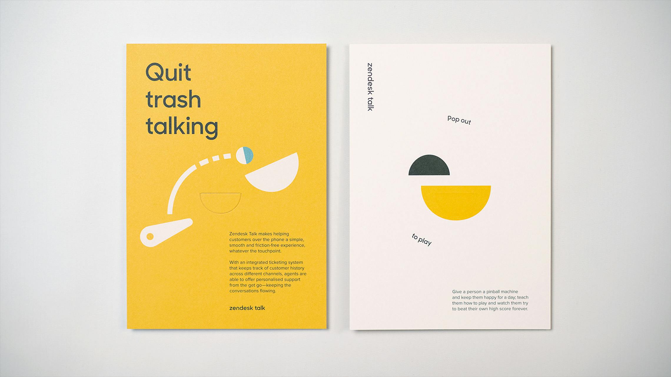 A side-by-side view of two Zendesk marketing cards against a white background. The left card is yellow, with the headline 'Quit trash talking,' a pinball graphic, and a description of Zendesk Talk. The right card is white, labeled 'Zendesk Talk,' and shows two perforated, pop-out shapes (one yellow, one dark grey) with the instructions 'Pop out to play.'