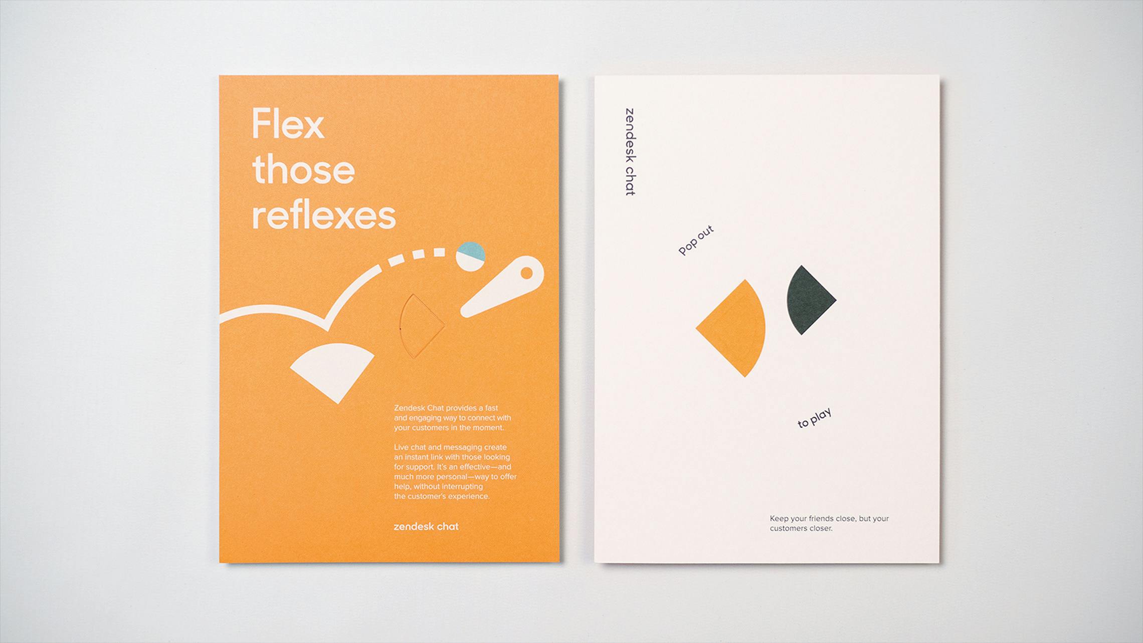 A side-by-side view of two Zendesk marketing cards against a white background. The left card is orange, with the headline 'Flex those reflexes,' a pinball graphic, and a description of Zendesk Chat. The right card is white, labeled 'Zendesk Chat,' and shows two perforated, pop-out shapes (one orange, one dark grey) with the instructions 'Pop out to play.