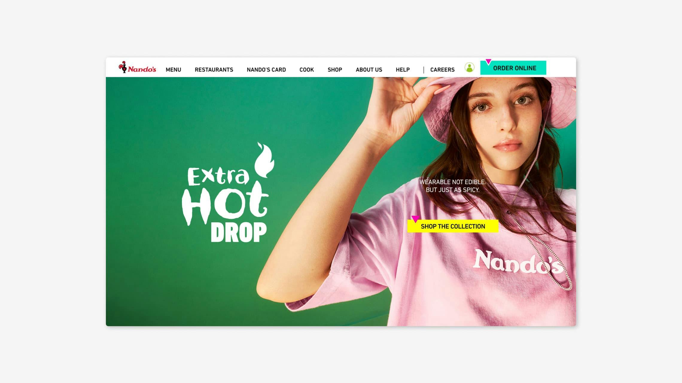 Nando's website homepage. The main banner advertises the 'Extra Hot Drop' merchandise collection. A young woman models a pink Nando's t-shirt and matching bucket hat, with the text 'WEARABLE NOT EDIBLE, BUT JUST AS SPICY' and a 'SHOP THE COLLECTION' button. The standard Nando's navigation bar is visible at the top.