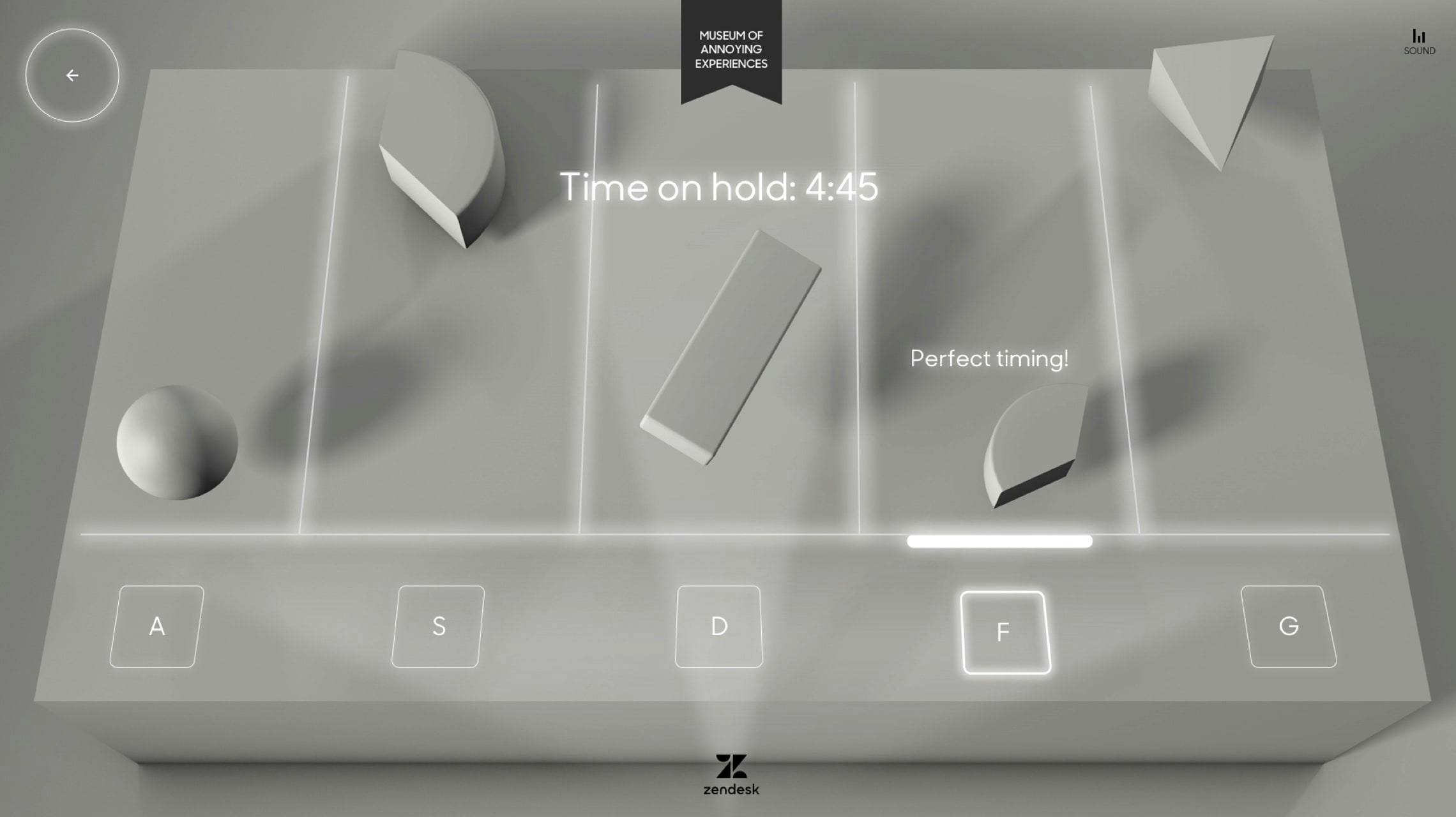 A monochromatic, 3D interface for a rhythm game from Zendesk's 'Museum of Annoying Experiences.' Geometric shapes (sphere, rectangle, pyramid, semi-circle) fall down five vertical lanes. Below these lanes are five glowing buttons labeled 'A,' 'S,' 'D,' 'F,' and 'G,' with the 'F' button highlighted. Text in the center reads 'Time on hold: 4:45,' and 'Perfect timing!' appears near a successfully hit shape. UI elements include a back arrow and a sound icon.