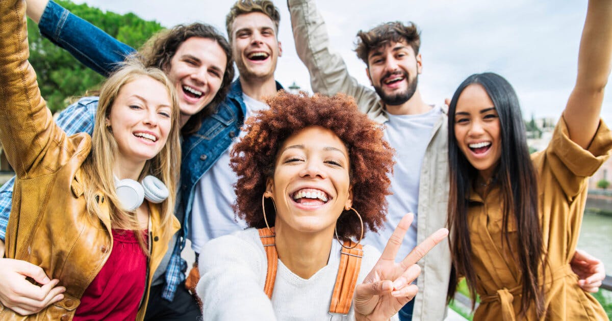 Grupo de jovens se divertindo na cidade, sorrindo e interagindo em um ambiente urbano vibrante e animado.