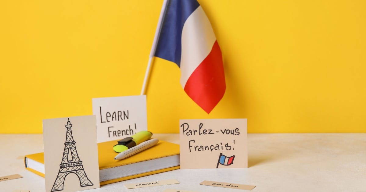 Cartões com a Torre Eiffel e a bandeira da França, representando a cultura do país, com o material de aula de francês.