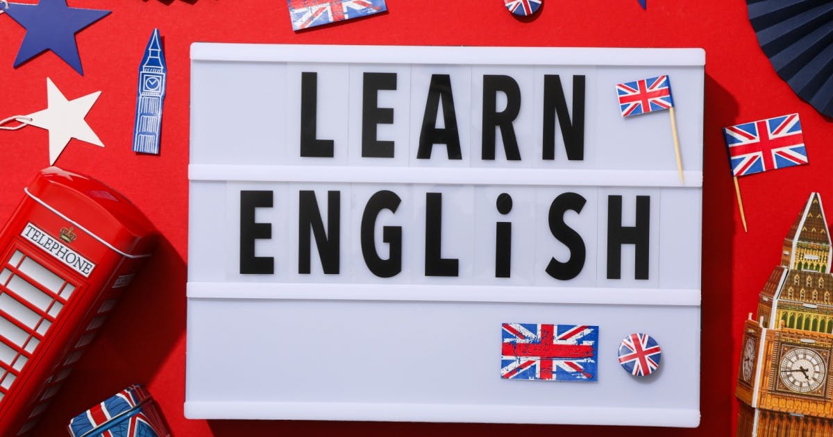 Placa com a mensagem "Learn English" e com bandeiras da Grã-Bretanha sobre um fundo vermelho com imagens da Inglaterra.