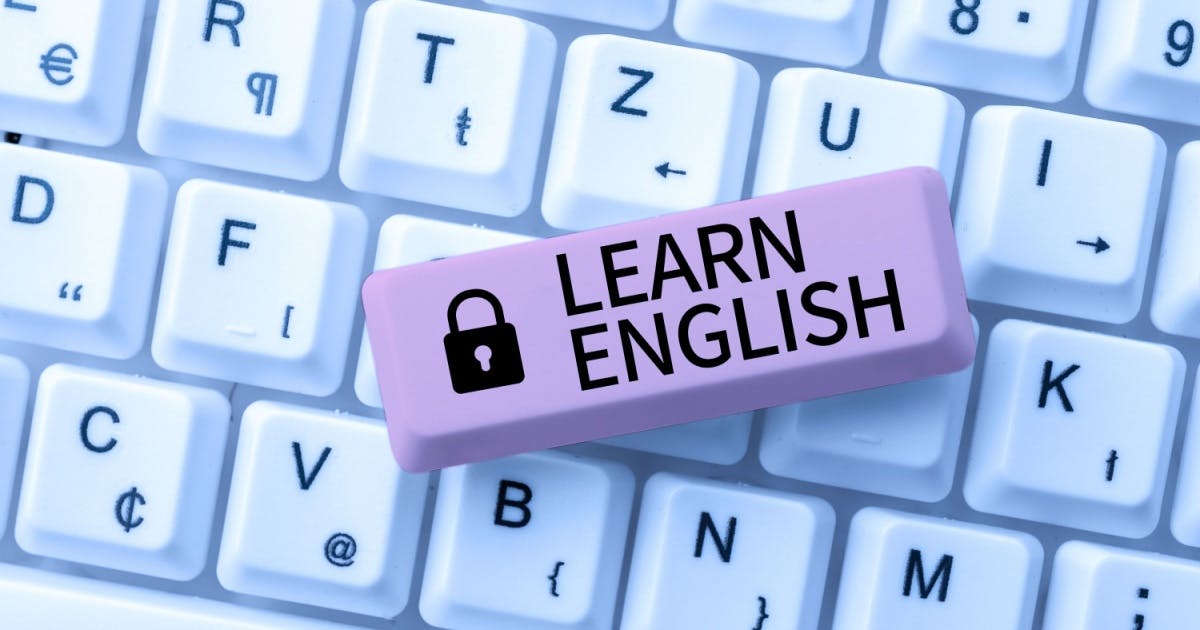 Peça de plástico lilás com a frase "Learn English" e o desenho de um cadeado, em cima de um teclado de computador branco.