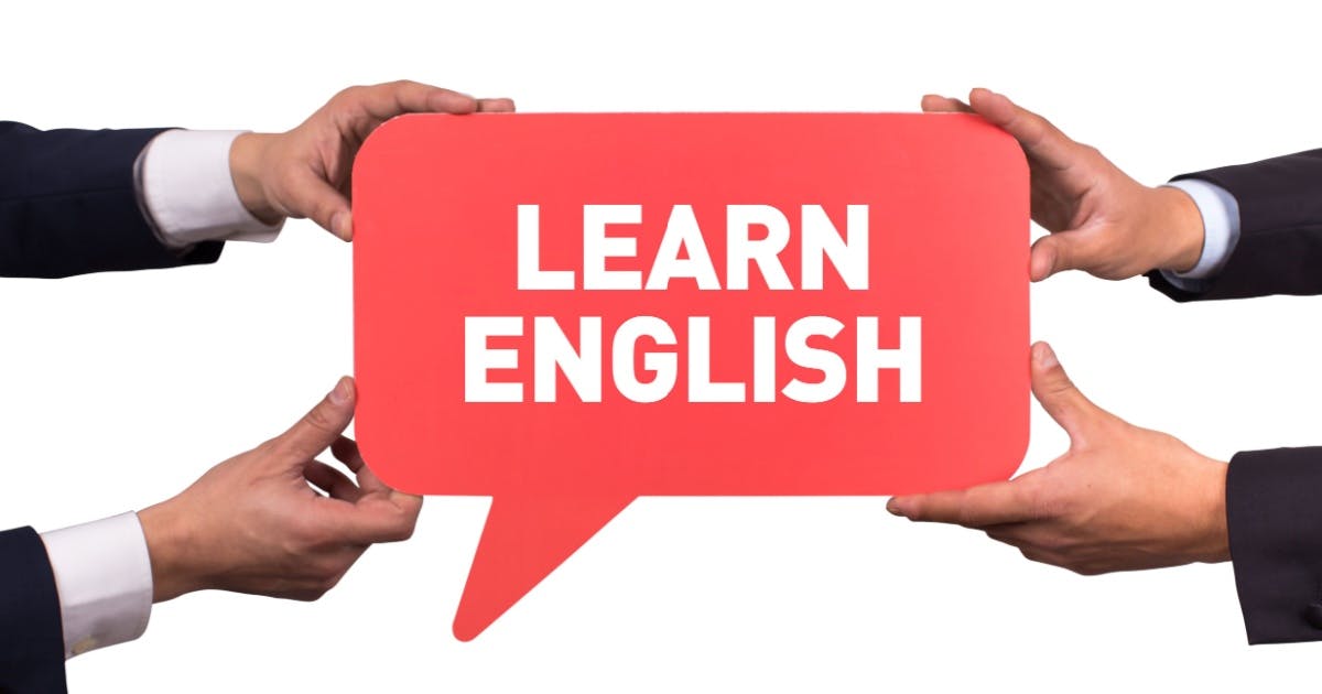 As mãos de dois homens de terno segurando um ícone que representa um balão de fala vermelho com a frase "Learn English".