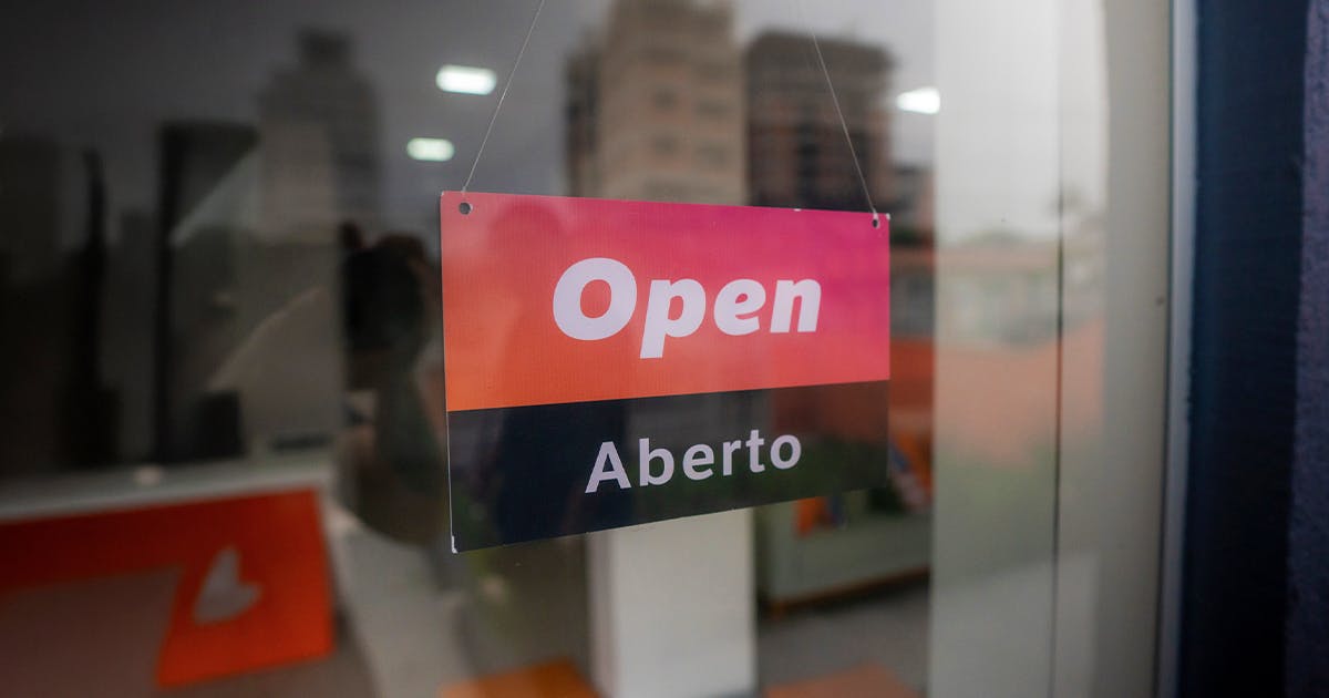 Placa de aberto em uma porta de vidro