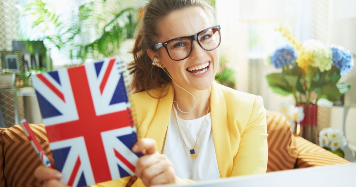 Jovem com um livro de inglês, praticando para se tornar poliglota com método leve e acessível.