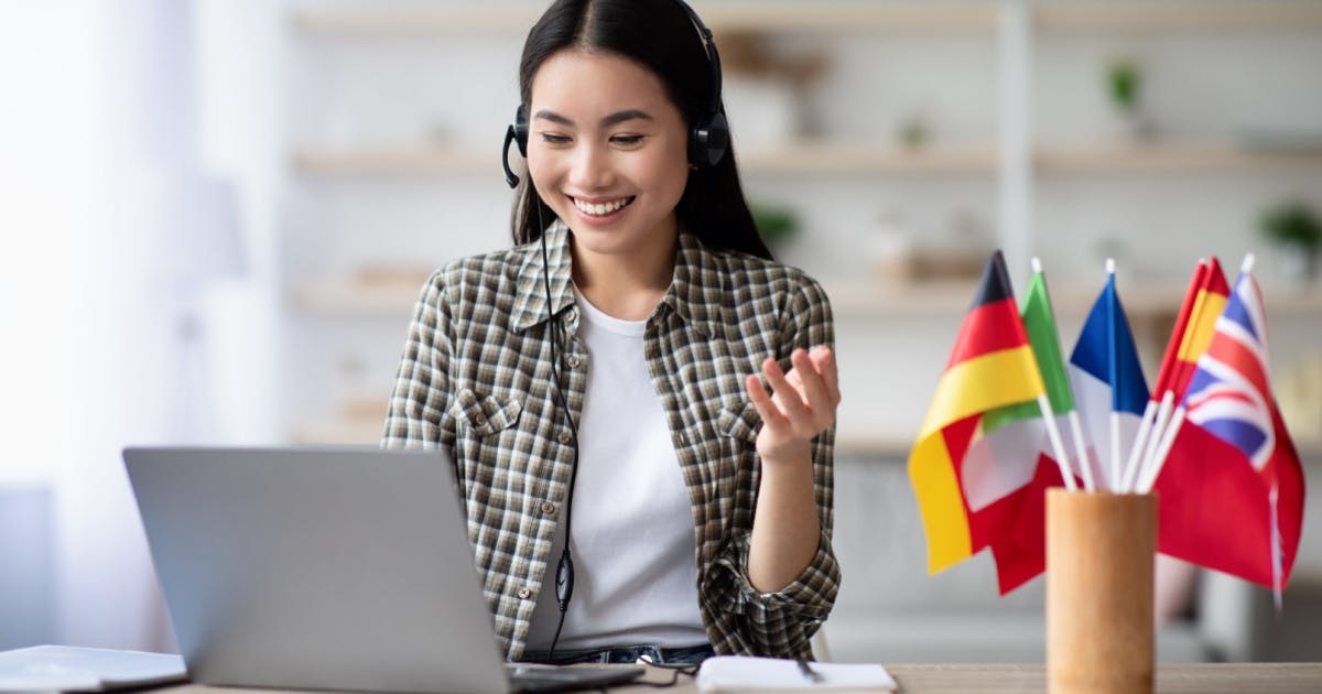 Jovem mulher explorando idiomas pelo laptop.
