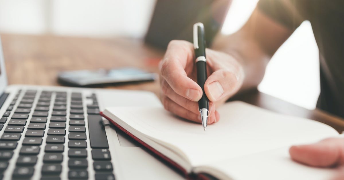 Estudante de inglês online desenvolvendo habilidades de escrita e gramática com anotações.