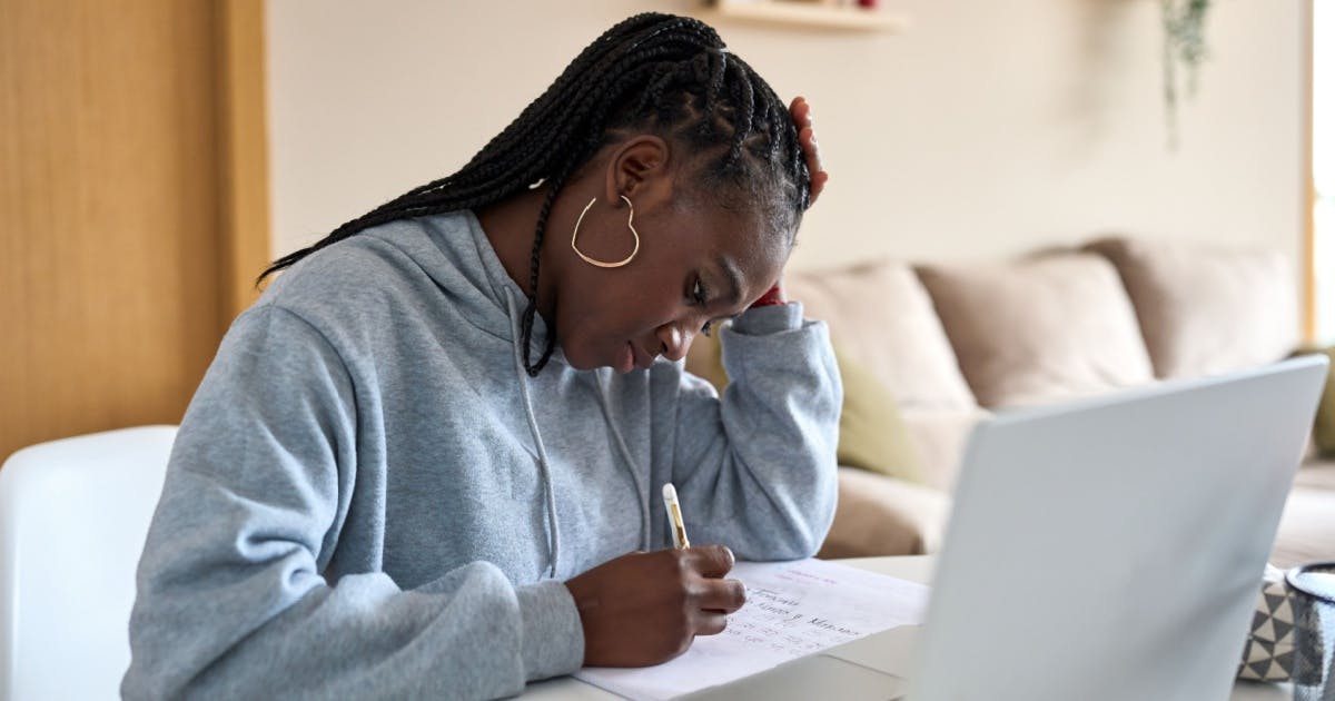 Aprender inglês sozinho: estudante praticando escrita sozinho em casa.
