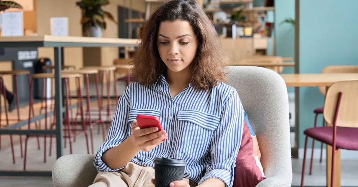 Pessoa estudando palavras em inglês pelo celular com lista de vocabulário.