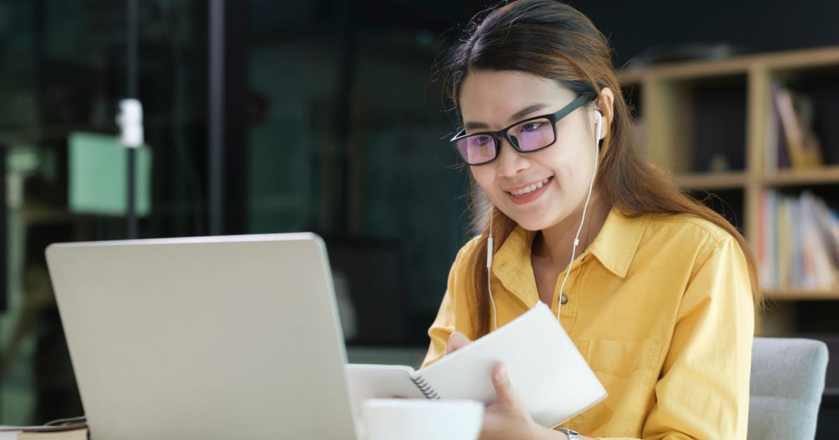 Músicas para estudar: pessoa estudando com fones de ouvido.