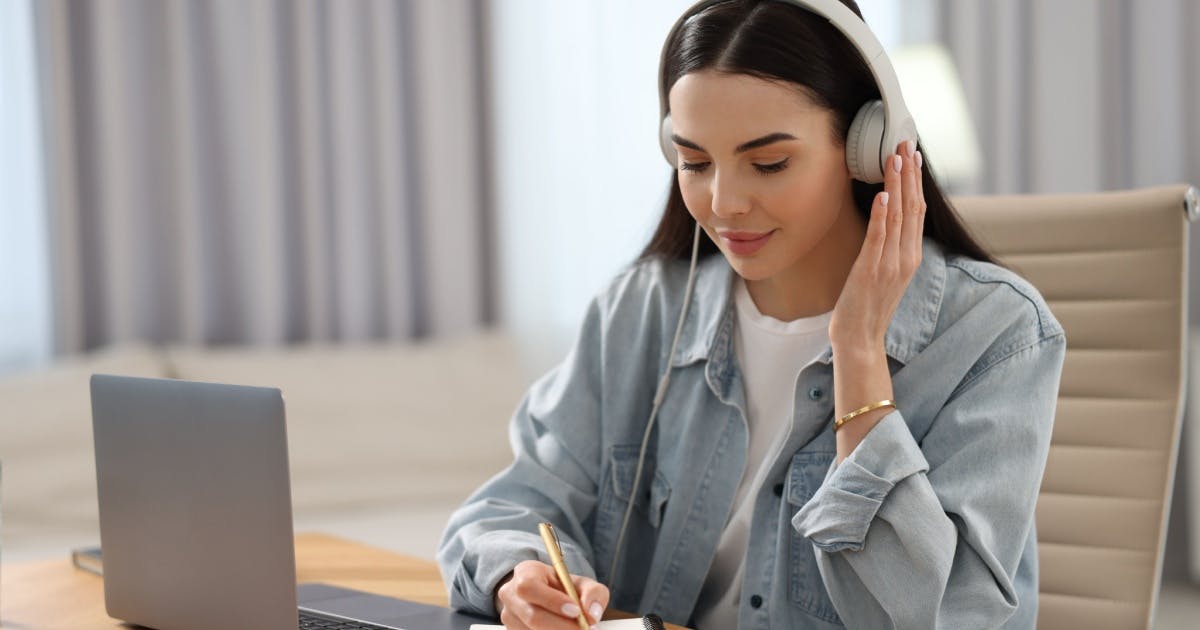 Músicas para estudar: pessoa trabalhando com fones de ouvido em home office.