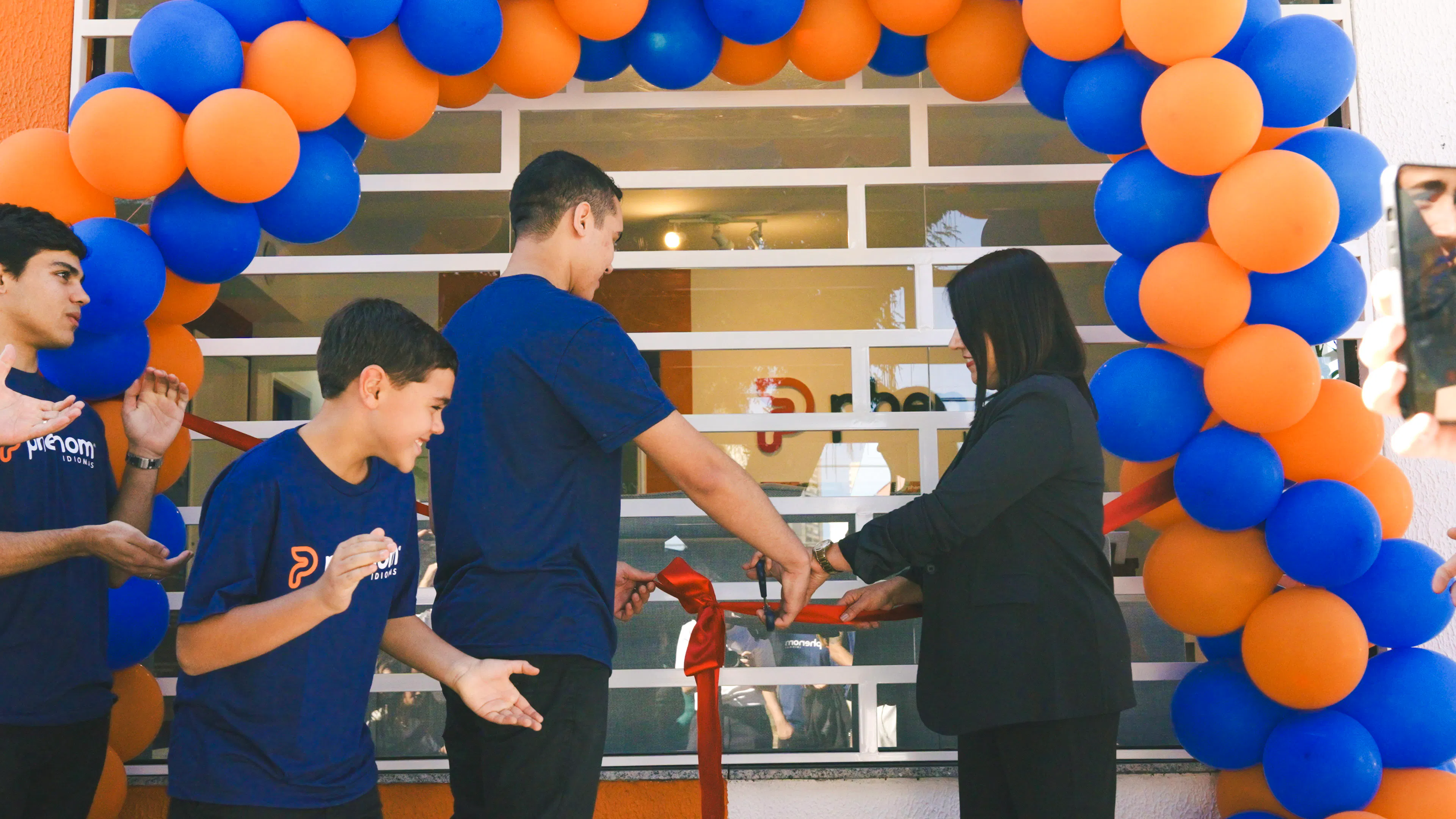 Patrícia e Felipe cortando a faixa de inauguração