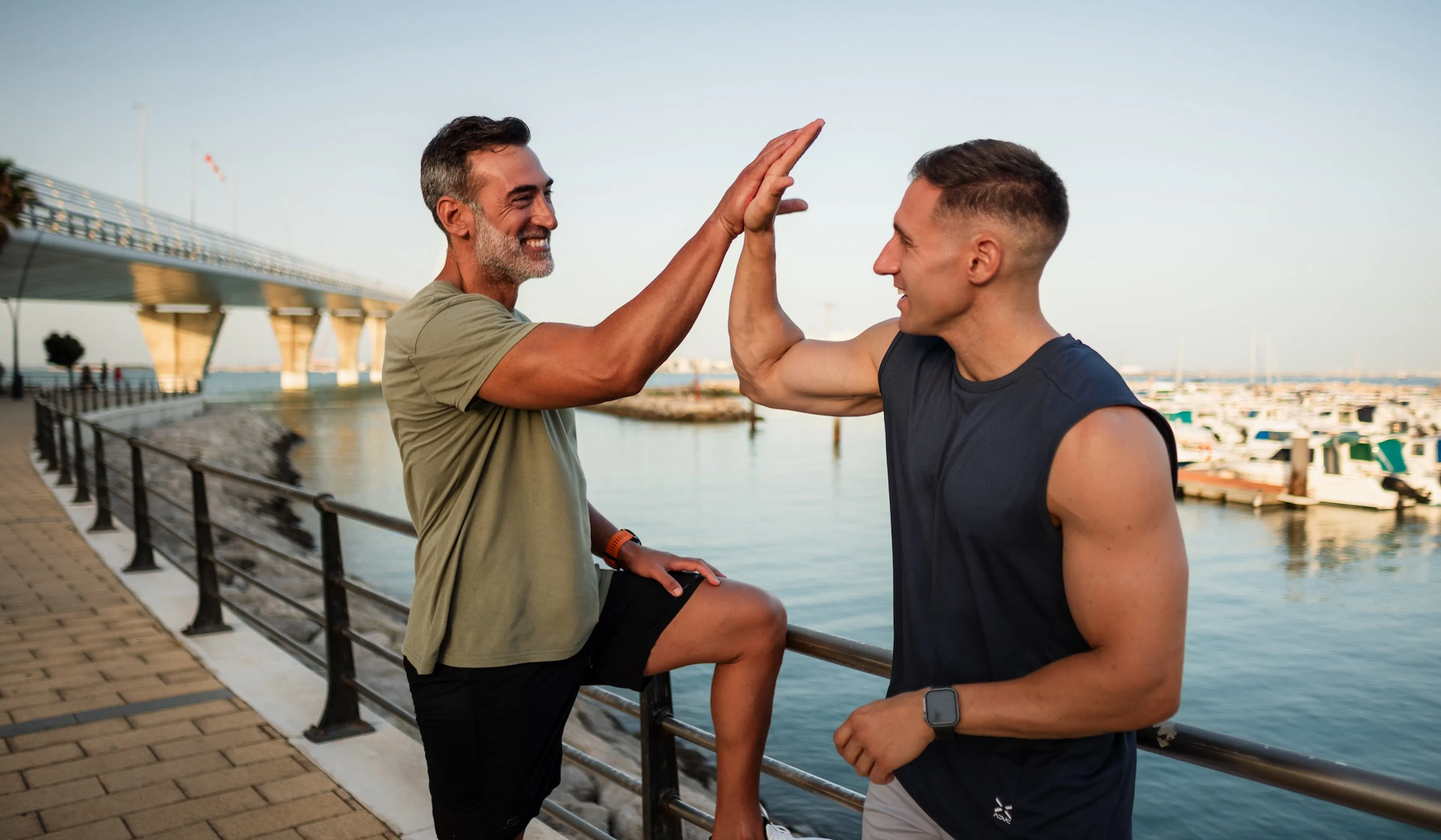 Two male athletes giving high five after workout