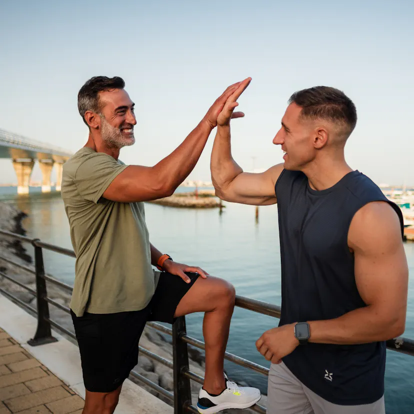 Two male athletes giving high five after workout