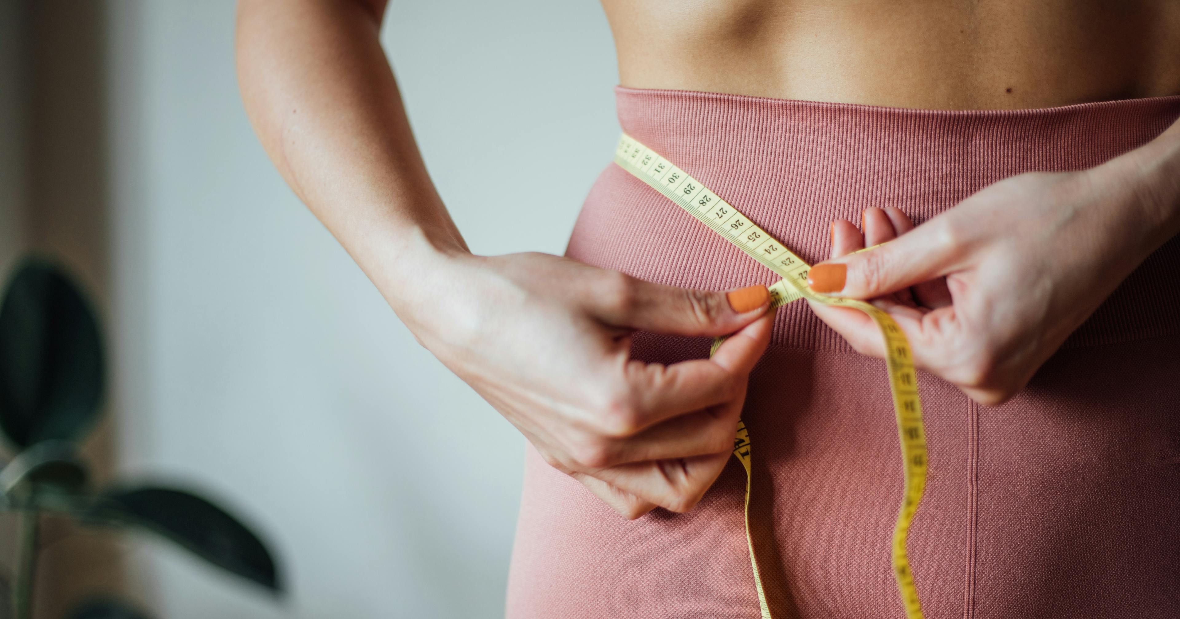 woman measuring her waist