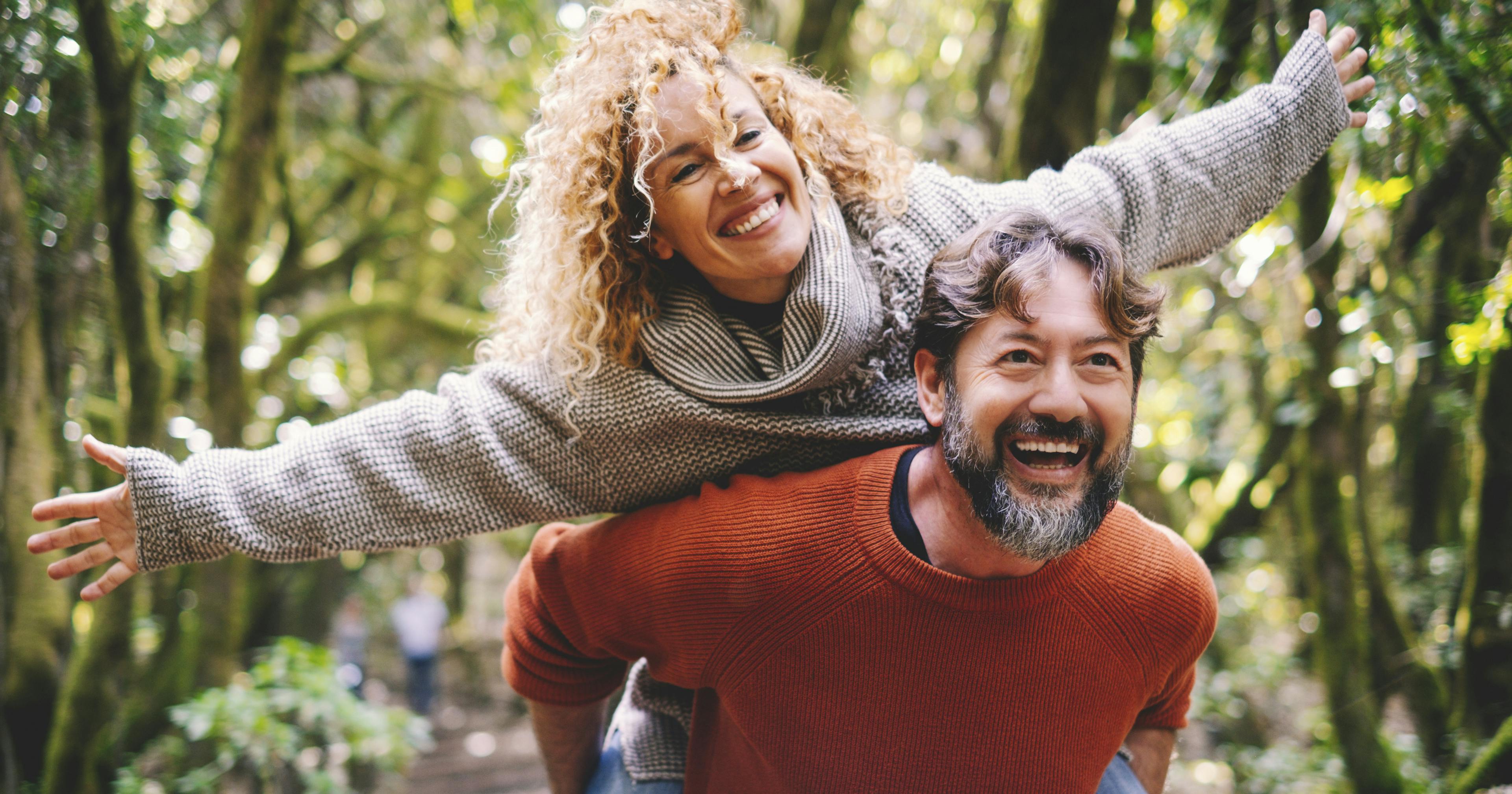 Overjoyed adult couple have fun together at outdoor park