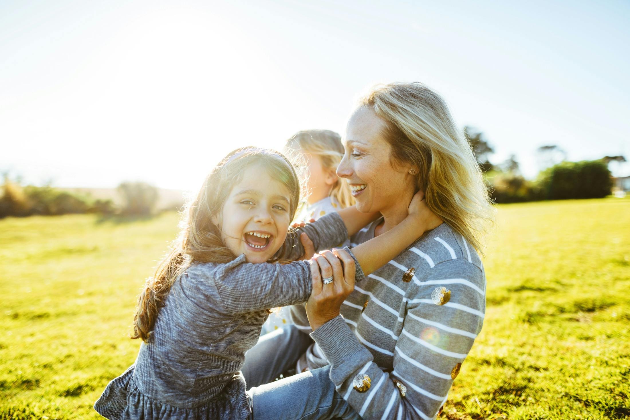 happy mom with kids in sunshine